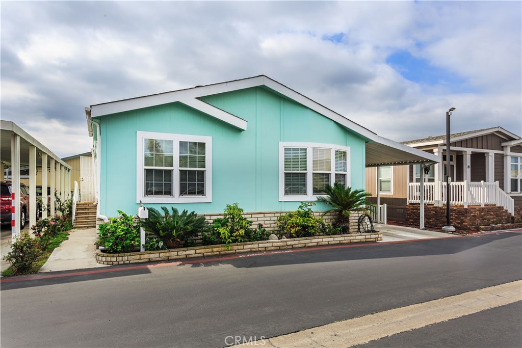 Great Opportunity to own this beautiful mobile home! Built in 2005 Oak manor Double wide Home in the distinguished area of Anaheim Mobile Estates. Featuring 1,568 sq ft this house is owned by the original owner!! With 3 Bedrooms, 2 baths and an additional BONUS ROOM that can be used as a EXTRA BEDROOM making it a total 4 BEDROOMS, It is perfect for a family looking for extra room space. Upon entering, you are greeted by an expansive open floor plan accentuated by soaring cathedral ceilings and a COZY FIREPLACE. The spacious kitchen is both functional and stylish, featuring a charming breakfast nook, formal dining area, a gas stove, and an abundance of cabinetry. The Kitchen island featuring its own sink enhance the space, making it a delightful setting for culinary adventures. The spacious master suite serves as a tranquil retreat, complete with a built-in wall bonus room ideal for a home office and a private master bath featuring a separate shower, SOAKING JACUZZI and two vanity sinks. The bedrooms, each on the opposite side of the house offer generous closet space and a restful atmosphere. The Hall bath features a skylight for natural lighting and a bathtub. Both double glazed sliding and double hung windows are featured throughout the house. The convenience of an inside laundry room with full-size washer and dryer adds to the home's practicality. The house has an outside 6'x8' shed with electric lights and receptacles offering extra storage space. The Carport can accommodate up to 3 vehicles and there is additional marked guest parking throughout the park. This home has been impeccably maintained by the original owners. Great location in Anaheim close to fine dining, shopping, entertaining and freeways. The Community amenities include a community pool, jacuzzi and clubhouse, enhancing the overall appeal of this beautiful property. Make this beautiful Mobile Home Yours Today!