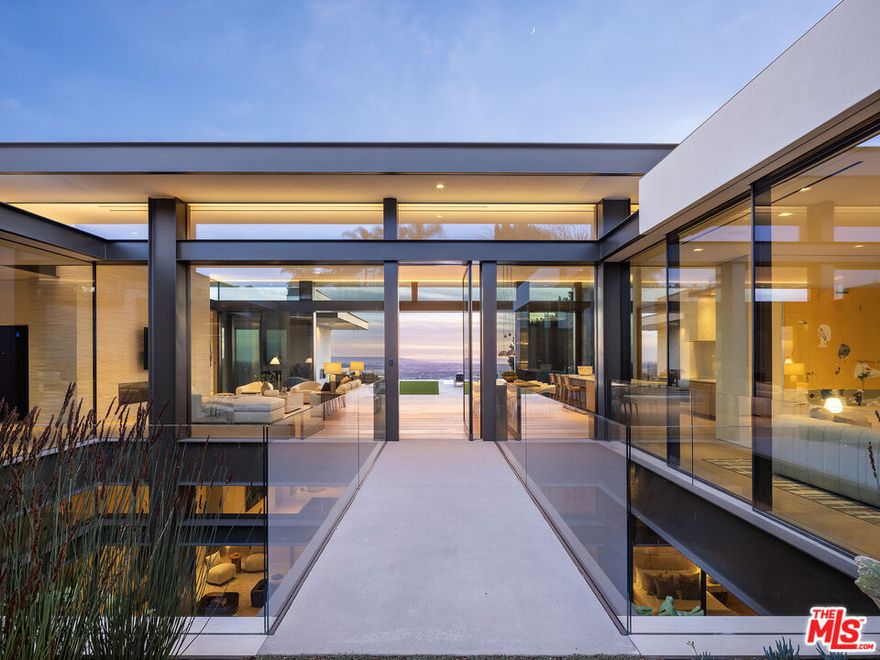 Indulge all of your senses in this brand-new Contemporary marvel located in the prestigious Bird Streets. Showcasing supreme quality with the finest materials, this estate embodies luxurious Los Angeles living and is the ultimate view estate with unobstructed jetliner vistas from Century City to the Pacific Ocean. A masterful creation by Paul McClean architecture, built by Dugally Oberfeld, and interior design and finishes by Marmol Radziner, this home features every conceivable amenity. Spanning approx. 13,400 sq.ft. of living space with 7 bedrooms and 9 bathrooms, there is ample space for friends, family, staff, and entertaining. Offering privacy and security, a gated driveway leads to a subterranean 8-car garage and the gated front entryway leads to the glass front door across a bridge spanning above the lower level interior courtyard oasis. Equipped with state-of-the-art smart home technology and custom automated walls of glass that amplify the incredible views throughout. The main level offers a grand living room with fireplace, dining area, expansive kitchen with enormous island and Wolf and Subzero appliances, family room, powder room, two guest bedroom suites with one furnished as an office, and the beautiful primary bedroom suite with walls of glass and terrace overlooking the views, fireplace, dual walk-in custom closets, and Afyon White Slab marble bathroom. The living room and primary bedroom flow into the exterior space featuring lounging terraces, fireplace, synthetic turf, and zero-edged pool and spa. Descend the floating staircase or take the elevator to the lower level which offers an incredible entertainer's oasis and wellness retreat. Features include a living room with large built-in bar, game/billiard room, glass wine display, gorgeous theater/media room, huge gym with walls of glass to covered patio, and spa with massage room, large shower and sauna. There is also a remarkable interior courtyard Zen-garden with water wall and the most beautiful living wall that brings light and nature inside. The lower level is complete with a guest suite, powder room, laundry room, and two staff suites. Discover this ultimate hillside oasis just moments from the excitement of Sunset Blvd and the best of Los Angeles dining, shopping, entertainment, and nightlife.