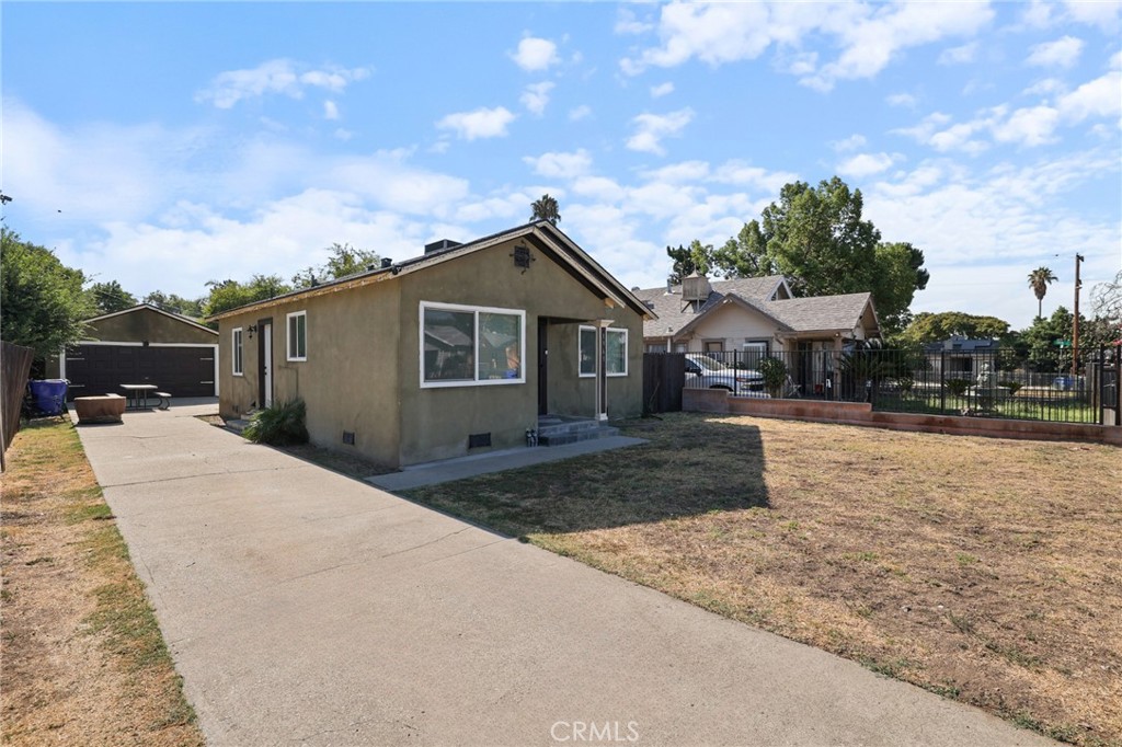 Single-story charmer with modern updates and room to grow! This 2-bedroom, 1-bath home features crown molding, updated lighting, a cozy fireplace accent wall, and a bright open layout connecting the living, dining, and kitchen areas. The kitchen offers ample cabinetry, granite-style counters, and a breakfast bar. Detached 2-car garage and long driveway provide abundant parking, with a spacious backyard offering ADU potential, garden space, or outdoor entertaining. Convenient location near schools, parks, shopping, and freeway access.