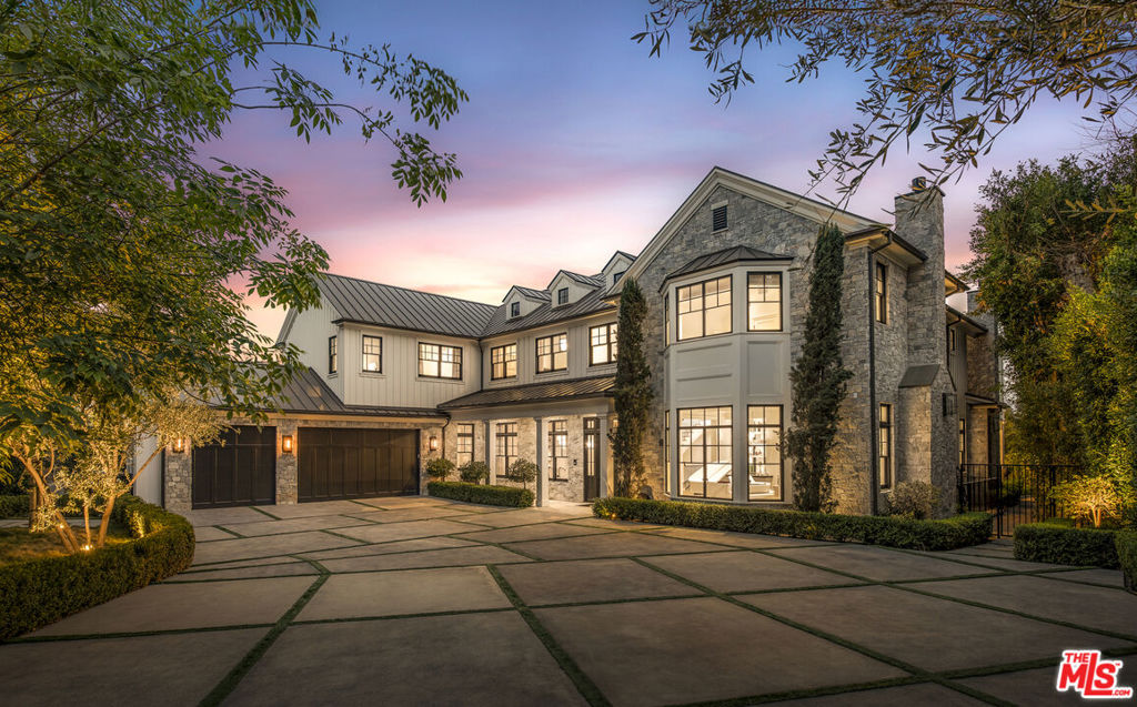 Nestled along a private drive in the prestigious Brentwood Park neighborhood, this newly completed estate by renowned architect Ken Ungar is a marvel of grand scale and modern sophistication with expansive views. Set beyond gates, the residence harmoniously blends timeless traditional design with contemporary luxuries, offering exquisite craftsmanship and cutting-edge home tech, such as Crestron home automation, Lutron lighting, Sonos sound integration, and an 8K security camera system. Enter to a dramatic two-story foyer with soaring ceilings and a sweeping staircase that sets the tone for an impressive aesthetic. White oak floors flow into elegant formal living and dining rooms, adorned with coffered ceilings, bespoke lighting, and a stately fireplace. The south-facing home beckons sunlight to pour through walls of windows, framing lush greenery and seamlessly connecting the interiors to the outdoors. The chef's kitchen is a true centerpiece, featuring light-toned cabinetry, striking stone countertops, beamed ceilings, and professional-grade Wolf and Sub-Zero appliances, along with a built-in Miele coffee station and a butler's pantry for added convenience. The upper level is crowned by a spectacular primary suite with far-reaching views, a private sanctuary with a fireside sitting area, private balcony, dual custom wardrobes, and a spa-like bath outfitted with book-matched marble finishes, a soaking tub, and a glass-enclosed shower. Each additional bedroom on this level features vaulted ceilings, en suite bathrooms, and refined detailing. The lower level is a haven for relaxation and entertainment, boasting a theater, a temperature-controlled wine room, a lounge with a sleek bar, a fitness studio, and a glam room for hair, nail, massage, and beauty treatments. Outside, the estate's resort-style amenities include a sprawling backyard with breathtaking, unobstructed city and canyon views, a sparkling pool with an automatic cover, a spa, and a heated alfresco dining pavilion complete with an outdoor kitchen and fireplace. There is also a versatile side yard with a fire pit and Bocce court. In addition, there are proposed plans to add a sports court with a viewing patio. With parking for up to fourteen vehicles between the expanded motor court and attached three-car garage, this estate is as functional as it is luxurious. Set along a coveted private drive in Brentwood Park, this tranquil estate offers unparalleled privacy and prestige. Supremely positioned for effortless access to Brentwood, Santa Monica, Beverly Hills, and the Westside's finest schools, delivering a lifestyle of unmatched sophistication in one of the city's most exclusive enclaves.