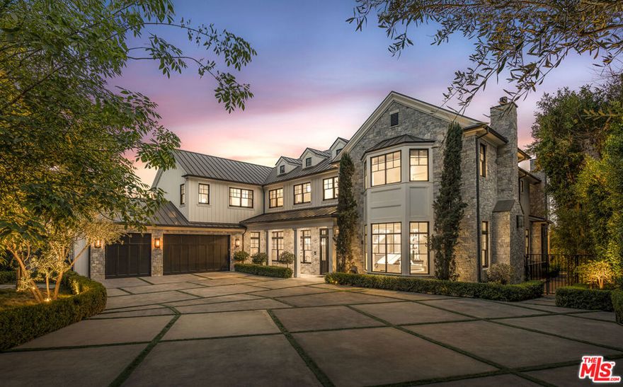 Nestled along a private drive in the prestigious Brentwood Park neighborhood, this newly completed estate by renowned architect Ken Ungar is a marvel of grand scale and modern sophistication with expansive views. Set beyond gates, the residence harmoniously blends timeless traditional design with contemporary luxuries, offering exquisite craftsmanship and cutting-edge home tech, such as Crestron home automation, Lutron lighting, Sonos sound integration, and an 8K security camera system. Enter to a dramatic two-story foyer with soaring ceilings and a sweeping staircase that sets the tone for an impressive aesthetic. White oak floors flow into elegant formal living and dining rooms, adorned with coffered ceilings, bespoke lighting, and a stately fireplace. The south-facing home beckons sunlight to pour through walls of windows, framing lush greenery and seamlessly connecting the interiors to the outdoors. The chef's kitchen is a true centerpiece, featuring light-toned cabinetry, striking stone countertops, beamed ceilings, and professional-grade Wolf and Sub-Zero appliances, along with a built-in Miele coffee station and a butler's pantry for added convenience. The upper level is crowned by a spectacular primary suite with far-reaching views, a private sanctuary with a fireside sitting area, private balcony, dual custom wardrobes, and a spa-like bath outfitted with book-matched marble finishes, a soaking tub, and a glass-enclosed shower. Each additional bedroom on this level features vaulted ceilings, en suite bathrooms, and refined detailing. The lower level is a haven for relaxation and entertainment, boasting a theater, a temperature-controlled wine room, a lounge with a sleek bar, a fitness studio, and a glam room for hair, nail, massage, and beauty treatments. Outside, the estate's resort-style amenities include a sprawling backyard with breathtaking, unobstructed city and canyon views, a sparkling pool with an automatic cover, a spa, and a heated alfresco dining pavilion complete with an outdoor kitchen and fireplace. There is also a versatile side yard with a fire pit and Bocce court. In addition, there are proposed plans to add a sports court with a viewing patio. With parking for up to fourteen vehicles between the expanded motor court and attached three-car garage, this estate is as functional as it is luxurious. Set along a coveted private drive in Brentwood Park, this tranquil estate offers unparalleled privacy and prestige. Supremely positioned for effortless access to Brentwood, Santa Monica, Beverly Hills, and the Westside's finest schools, delivering a lifestyle of unmatched sophistication in one of the city's most exclusive enclaves.