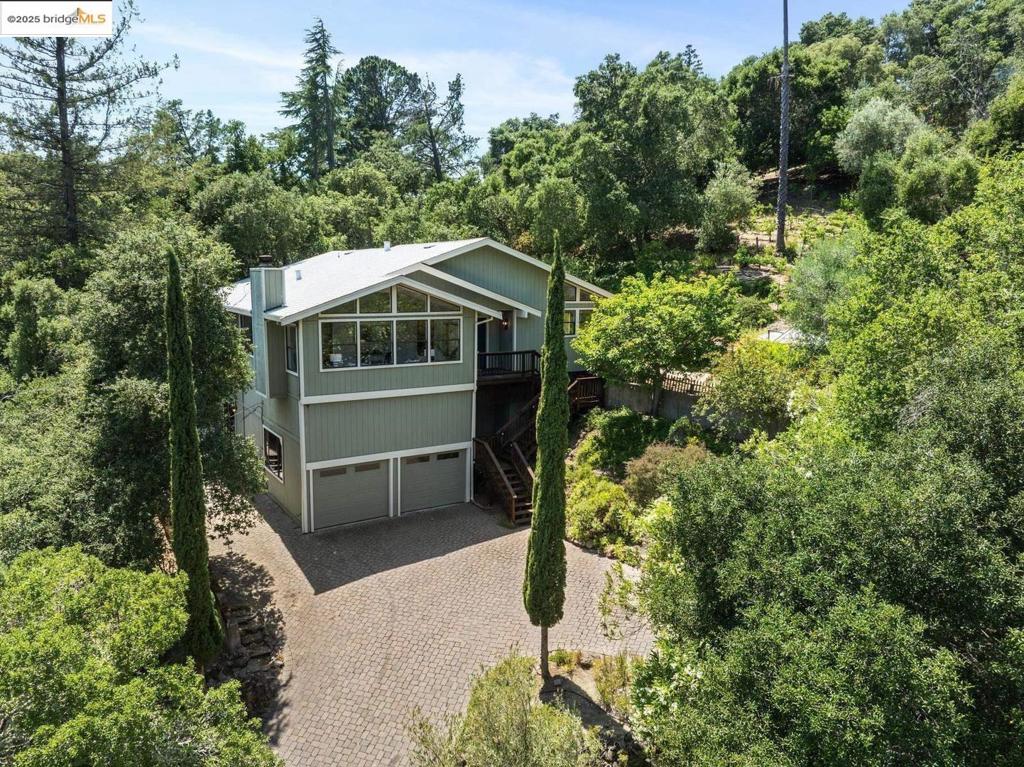 Perched on a serene hillside in Orinda’s coveted Charles Hill neighborhood, this light filled contemporary single-level retreat invites you to live among nature’s finest offerings. A wall of windows frames enchanting verdant views, from the sunlit vineyard to fragrant rose gardens, while soaring ceilings and a brick fireplace add warmth and elegance to the expansive living room. The formal dining room invites casual family gatherings and elegant holiday meals and dinner parties alike. The open flow from the kitchen and family room extends effortlessly to an expansive deck, made for summer meals overlooking your own hillside oasis. A luxurious primary suite provides private patio access for quiet reflection, while three additional bedrooms cater to comfort and versatility. A separate guest studio—complete with private deck, full kitchen, and bath(not included in bed/bath count)—creates endless possibilities for hosting friends, multi-gen living, or dedicated work-from-home space. Surrounded by olive, Meyer lemon, and fruit trees, this sunlit lot feels worlds away, yet you’re just minutes from downtown Orinda, Lafayette’s vibrant amenities, and Orinda’s highly acclaimed schools. Recently refreshed and move-in ready, 151 La Espiral is a home where every day feels like a getaway.