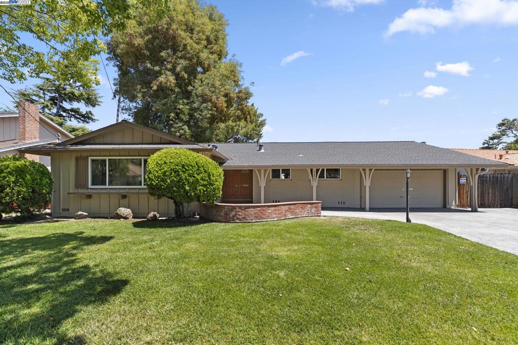Welcome to this thoughtfully updated 4-bed, 2-bath ranch-style home on a wide, tree-lined street in Newark’s desirable Rosemont neighborhood. Set on a generous 8,960 sq ft lot, this home offers charming curb appeal with mature landscaping and an extra-wide stamped concrete driveway. Inside, enjoy a step-down living room with high ceilings and backyard access, a family room with a classic brick fireplace and tall windows, and a versatile bonus room perfect for a home office or studio. The updated kitchen features granite countertops, stainless steel appliances, recessed lighting, and an open dining area with added storage. The primary suite includes new carpet and an ensuite bath with a tiled stall shower. Three additional bedrooms share an updated bath with dual vanities and a new shower/tub enclosure. A spacious backyard, deep 2-car garage, central A/C, dual pane windows, and fresh interior/exterior paint complete this move-in ready home—conveniently located near shops, parks, and major commute routes.