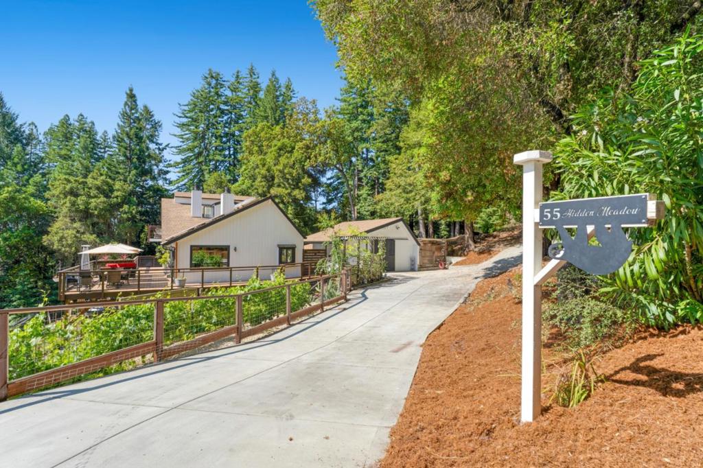 Tucked into the quiet beauty of Scotts Valley, but just minutes from town, this extraordinary estate invites you to live without compromise. At its heart, a meticulously curated 5+bed/3 bath main residence that is designed to live as one grand home or two distinct spaces. With spacious and sun drenched decks off the bedrooms and living spaces, enjoy the true meaning of indoor-outdoor living. Primary suite is on top level with its own laundry, bathroom, office and loft space. Lower level has two bedrooms/1 bathroom + large office (lives like three bedroom), full wet bar, and deck with hot tub. This property is ideal for multigenerational living!!! Conveniences such as large home theatre will make it so you never want to leave home. From the private vineyard to the mature fruit trees, sauna, hot tub, and multiple outdoor entertaining areas, step into a world of your own where you really can "have it all" at 55 Hidden Meadow.