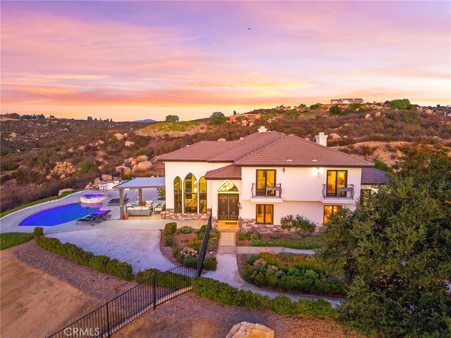 Chateau Evie James is a must-see hilltop estate in the heart of Temecula’s famed Wine Country. Set on over 5 acres with panoramic vineyard and valley views, this fully remodeled 5-bedroom, 4-bath residence offers the perfect blend of luxury, comfort, and turn-key convenience.
Inside, discover a thoughtfully reimagined floorplan with expansive dining and living spaces, brand-new flooring, and oversized view windows that flood the home with natural light. The chef’s kitchen is a true showpiece, featuring quartz countertops, custom cabinetry, an 8-burner gas stove, wine cooler, coffee bar, banquette seating, and under-drawer microwave, ideal for entertaining or everyday living. Every bathroom has been beautifully updated, with the primary suite boasting a spa-like retreat with a freestanding soaking tub and designer finishes. Additional highlights include:
A fully converted game room with mini split, arcade games, and shuffleboard
Two new AC units with Nest thermostats
Laundry room with two washers and dryers (included)
Designer lighting and an electric fireplace. 
Step outside to your own private resort: a sparkling new pool and spa, covered patio, BBQ island, bocce ball court, tiled patio spaces, and lush landscaping with smart irrigation. Whether enjoying a quiet morning coffee or hosting unforgettable gatherings, every moment is framed by absolutely amazing views!
Offered fully furnished, this estate is move-in ready and perfectly suited as a full-time residence, vacation home, or high-end short-term rental investment. Just minutes from world-class wineries, dining, and equestrian centers, this is Wine Country living at its finest.