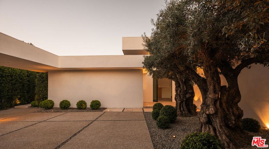 The Trousdale Oasis: Trousdale's most exquisite modern interpretation of the greatest era and lifestyle the world has ever known. One-of-a-kind tennis court estate on a double lot with explosive views. Designed by the legendary Edward Fickett, FAIA, king of the tennis court estates. The Mid-Century restoration of the ages, is a masterpiece born of the finest materials, leading style masters, and most coveted soil on earth. With the longest frontage of any house in Trousdale, it offers unobstructed panoramic views from the city to the ocean and as far as the eye can see. Set behind gates and lush 100-year old olive trees to provide the ultimate privacy and security. Open floor plan with 18-foot ceilings, exquisite finishes throughout including fluted Venetian plaster walls and rare blanco Travertine floors mixed with herringbone Fench Oak floors. Oversized family, dining, and living spaces with walls of glass to showcase the views. Arclinea kitchen features Miele appliances, and cabinets by Antonio Lupi. Custom bronze bar with wine cellar. The spacious primary suite has his and her separate bathrooms and walk-in closets, and balcony with views. Pocket glass doors disappear for seamless indoor/outdoor living. Lautner zero-edge swimming pool, spa, outdoor kitchen, fire pits, and multiple seating areas to take in immaculate views. The full-size North/South tennis court has grandfathered-in tennis court lights, which can never be done again in Trousdale. Now is your chance to own a piece of architectural history and luxury in the most exclusive neighborhood with the highest comps in the city, where every detail is designed for the ultimate in elegance and comfort, making this estate a truly once-in-a-lifetime opportunity to live the Beverly Hills dream.