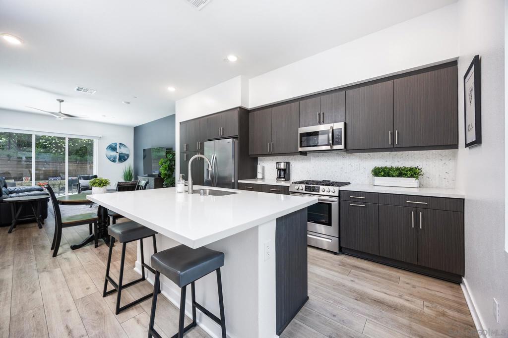 VA approved! Modern Living Near Snapdragon Stadium & SDSU. End-unit Townhome. Welcome to The Harlow—a sleek 2019 ColRich townhome offering modern design, thoughtful upgrades, and a central location. Just minutes from Snapdragon Stadium, SDSU, the trolley line, and the I-8, this home puts you close to beaches, downtown, and more, all within a well-maintained, low-HOA community. This 3-story home features an open floor plan with luxury vinyl plank flooring, quartz counters, stainless steel appliances, recessed lighting, and a center island with bar seating. A laundry closet with a full-size washer/dryer adds convenience, and a remote-controlled shade on the main floor enhances comfort. Upstairs, the primary suite includes a walk-in closet and upgraded en suite bath. Notable upgrades include custom paint, upgraded carpet upstairs, four ceiling fans, and a ceiling-mounted storage rack in the garage. Enjoy outdoor living with a private backyard featuring pavers, river rock, and low-maintenance turf. Parking includes a 2-car attached garage, plus a 2-car carport—parking for 4 total. If you’re seeking low-maintenance style in a prime San Diego location, this one checks all the boxes. VA Approved