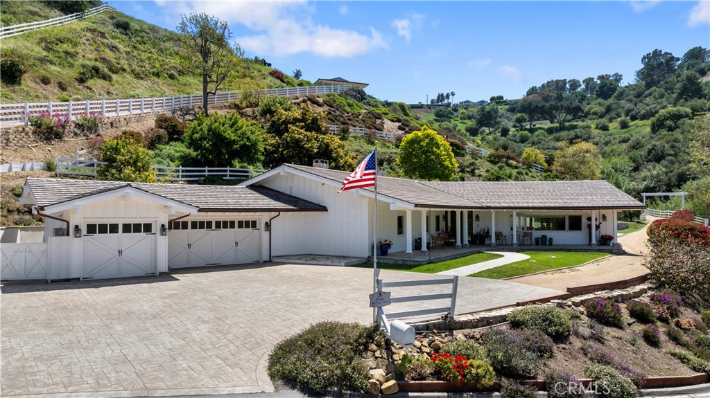 Nestled in a serene and private enclave between the canyons of the exclusive gate city of Rolling Hills, this extraordinary 2.7-acre equestrian estate offers a rare blend of luxury and nature. Completely renovated in 2023, the main residence spans approximately 3,833 sq. ft. and features 3 bedrooms and 3.5 bathrooms. The floorplan includes an expansive great room with soaring wood-beamed ceilings, gorgeous oak wood flooring, a stunning stacked stone fireplace, and custom finishes throughout. The gourmet kitchen is a showstopper, outfitted with top-of-the-line Viking and Sub-Zero appliances with a huge over 10 foot island, perfect for entertaining. The flexible floorplan includes a generous multi-purpose room—ideal as a home gym, game room, or easily converted to a fourth bedroom or private office. Step outside and you’ll find a true entertainer’s paradise with a sparkling pool and spa, an outdoor bathroom, plus ample storage, all set against a tranquil, pastoral backdrop. Equestrian amenities include a 3-stall barn with tack room and hot walker, plus easy access to the community riding ring and an extensive network of scenic horse trails. Perched up its own private driveway, is a charming 1-bedroom guest house of over 800 sq. ft., complete with a cozy living room and kitchenette—perfect for visitors or extended stays—offering sweeping views of the rolling hills below. Don't miss the opportunity to own this exceptional and private retreat in the heart of Rolling Hills.