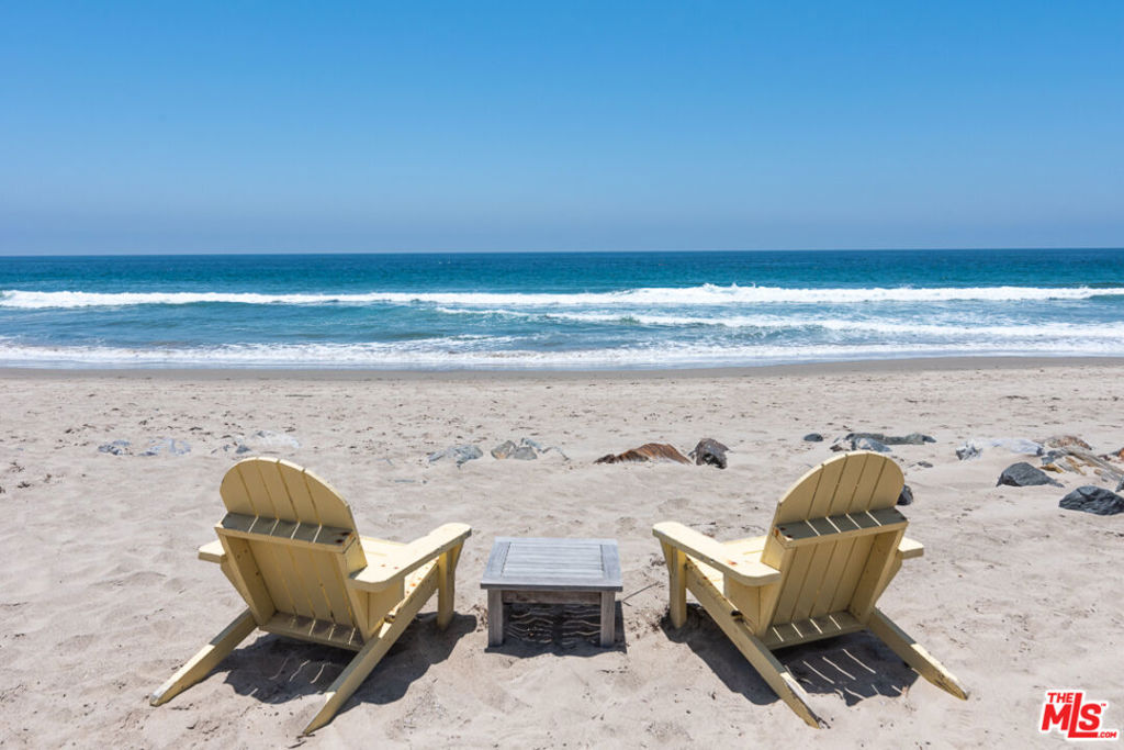 Nestled beautifully on Broad Beach, one of Malibu's most prized stretches, sits this magical & inviting compound surrounded by verdant beauty at the ocean's edge. Celebrity owners include Goldie Hawn & Kurt Russell amongst others very notable individuals. Once past the gated entry & charming courtyard, an exquisite mix of materials sing in perfect harmony as a dramatic staircase & double height ceiling open to unparalleled sea, sun & whitewater views. A living room w/fireplace leads to a formal dining room & chef's kitchen, as large expanses of glass provide a seamless connection between indoor & outdoor living. A stone patio & covered outdoor space w/ fireplace + built-in BBQ provide the perfect venue for entertainment, whilst lush landscaping, sweeping lawn & path lead to sandy dunes. All told, there are 4 retreat-like bedrooms & 5 baths, including a primary w/a spa-inspired bath w/onyx surfaces & wardrobe closet. As a bonus, there is a 2-room guest suite with a full bath located above a 3-car garage. Screening room complete this rare & impressive offering.