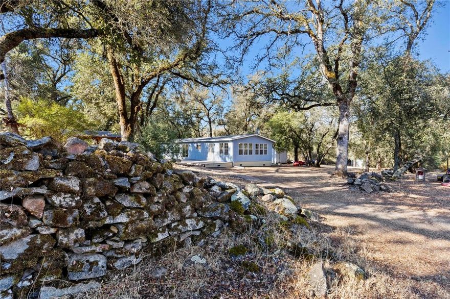 This fantastic property is back on the market! Discover a secluded gem in Northern California, rich in history and nature! This 23+ acre property has the special "Chinese Walls" built by 19th-century Chinese workers, along with an updated manufactured home on permanent foundation (making it lendable), seasonal pond + multiple creeks, detached 2-car garage with bonus room and power, second metal garage with rollup doors for storing equipment and recreational vehicles, and a covered patio for outdoor enjoyment. The home offers a fresh, airy feel with new paint inside and out, new waterproof laminate flooring, dual-pane windows + sliding glass doors, and composite decking on both the front and back of the house. The property is fenced and cross-fenced for livestock or horses, and comes with a tractor and two 1000-gallon water storage tanks. The washer and dryer, kitchen appliances, owned propane tank, and backup generator also stay with the property. Rest easy with the added security of the driveway gate, security screen door, great neighbors who look out for each other, a newly installed composite shingle roof, new gutters with covers, new skirting, and high-speed internet availability to stay connected in a rural area. Come make this turnkey, park-like property your own!