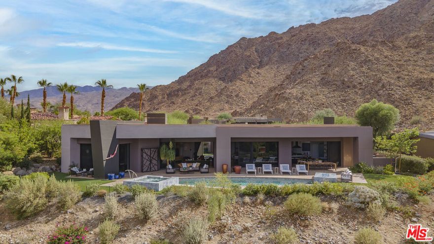 Located inside the gates of Ironwood Country Club, this striking modern home offers a rare blend of clean-lined design and effortless desert living. Walls of glass frame sweeping mountain and valley views, while natural light pours across the open layout. The residence features four bedrooms and four baths, including a dramatic primary suite with fireplace, dual walk-in closets, two water closets (one with smart toilet), and a spa-inspired bath with cold plunge tub and oversized shower. Two ensuite guest rooms add privacy, with a fourth bedroom currently serving as a fitness room. A newly updated chef's kitchen showcases premium appliances, built-in wine fridge, and oversized sunken wet bar perfect for entertaining against a backdrop of desert scenery. Outside, the refreshed pool and spa create a private retreat surrounded by drought-tolerant landscaping. Sustainability comes built-in with owned solar, newer HVAC, and a tankless water heater. Situated at the end of a cul-de-sac, this home delivers luxury, seclusion, and some of the most captivating views in the community.