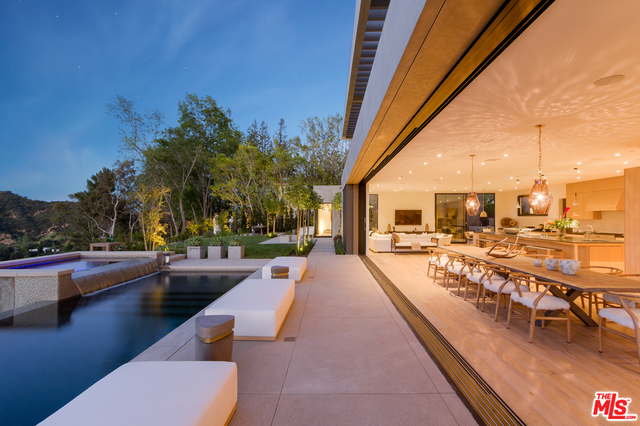 Gated estate compound set on a promontory atop one of Bel Air's most scenic ridgelines. A symphony of nature surrounds this natural setting framing the dramatic Bauhaus-vibe modern architecture. This new estate is oriented to take in the entirety of the reservoir lake views. Complete privacy is felt in all areas, even though a virtual transparency exists between interior and exterior. Motorized sliding glass walls disappear silently, bringing fresh breezes inside. Features include wire-brushed oak floors, rough-hewn stone walls, & soft-touch kitchen cabinets. Grand scale Kitchen & family eating areas plus a Caterer's kitchen allow for both small- and large-scale entertaining flawlessly. An unforgettable Master Suite offers 6 rms proving Fantasy can become Reality. Guest House, Theatre, Gym/Yoga Studio, Ocean View Lounge, Zero edge Pool, Outdoor Dining Pavilion, Grilling courtyard, Motorcourt and dual double garages begin an endless list of amenities. Sublime poetic luxury.