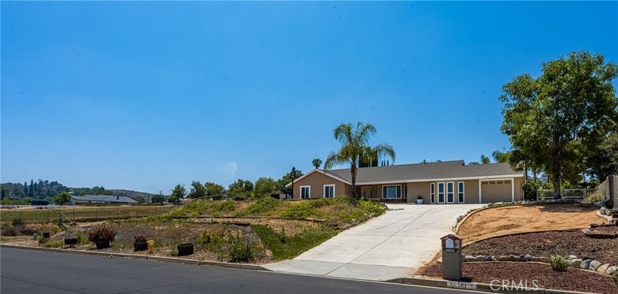 Set amid the scenic rolling hills of Woodcrest, 16481 Valle Vista Way presents a rare opportunity to own an authentic horse property that combines rural tranquility with everyday convenience. This single-story ranch-style residence offers 4 bedrooms, 2 bathrooms, and approximately 1,914 square feet of comfortable living space, set on an elevated 0.88-acre lot ideal for equestrian use or future expansion. Inside, a spacious living room opens to an upgraded kitchen featuring generous cabinetry and counter space, while the adjacent dining area provides a welcoming setting for family gatherings or entertaining. The well-appointed bedrooms include a primary suite with a private bath and ample wardrobe storage. Recent improvements include fresh interior and exterior paint and all-new carpet throughout. A thoughtful garage conversion has transformed the original 3-car configuration into a versatile space that now includes a 5th bedroom, 3rd bathroom, and a 1-car garage—perfect for guests, a home office, or multi-generational living. Outdoors, the newly renovated pool and spa create a private oasis surrounded by open land with endless possibilities. The property also features a long private driveway, paid-off solar, and ample room for RV parking, animal facilities, or additional structures. Zoned for horses and enveloped by rural charm, this home offers a true country lifestyle without sacrificing modern convenience. Located in one of Woodcrest’s most desirable areas, this property offers easy access to top-rated schools, shopping, and major freeways—blending privacy, functionality, and the best of Southern California living.