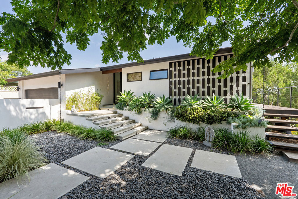 Nicely situated at the end of a cul-de-sac in a lovely pocket of Laurel Hills lies this beautifully updated single-story home with soaring city and canyon views. This 3-bedroom, 4-bathroom residence features a bright and open floor plan with stunning finishes, including Walnut cabinetry, French oak wood floors, and Miele appliances throughout. Designed for entertainment, the sun-soaked formal living room with fireplace and dining room boast incredible views and Fleetwood sliding glass doors with auto shades that open to the rear yard with a large pool. An Ipe wraparound deck, spanning over 1200 square feet, provides access to the main suite, guest suite, kitchen, dining, and living rooms. The main suite includes luxurious appointments such as a custom wardrobe and spacious bath. An additional 2 en-suite bedrooms, powder room, laundry, and 2-car garage with Tesla charger complete the home. In close proximity to Beverly Hills and The Valley and has access to the Wonderland School District.