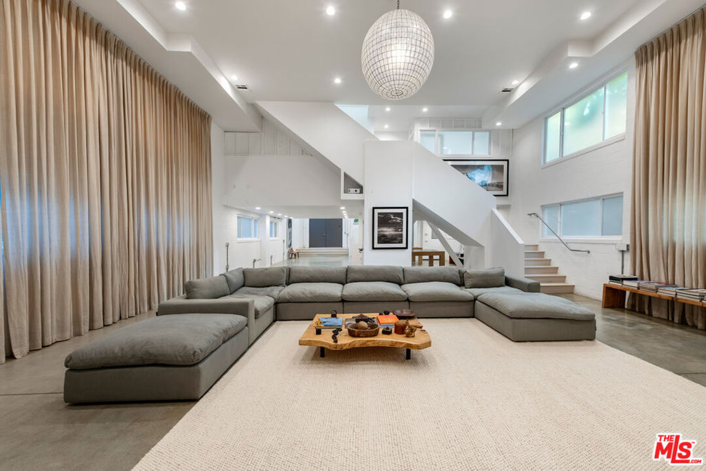 Welcome to a true masterpiece of modern luxury living in the heart of Venice Beach, where the charm of this coastal enclave meets the sophistication of New York loft-style elegance. This exceptional property offers a harmonious blend of creativity, space, and limitless possibilities, spanning approximately 5,224 square feet of meticulously designed living space. With its unique features and unparalleled style, this residence is poised to exceed even the most discerning buyer's expectations. As you enter this remarkable home, you'll be greeted by an awe-inspiring first floor boasting soaring 17-foot ceilings that create a sense of grandeur and openness. The flowing layout effortlessly guides you through this space, showcasing a custom projector system that elegantly splashes images and videos onto an oversized white wall, providing you with a blank canvas to showcase your artistic visions or create a captivating entertainment experience for friends and family. Ascending to the mezzanine level, you'll discover two generously sized bedrooms that have a beautifully designed bathroom. These tranquil retreats offer a peaceful haven to unwind and rejuvenate, with abundant natural light and thoughtful details that enhance the overall ambiance. The journey continues to the top level of this residence, where an impressive combination of living, dining, and relaxation awaits. The chef's kitchen is a masterpiece in itself, featuring high-end commercial-grade appliances, ample storage, and skylights that flood the space with warm natural light. This kitchen is designed to cater to the culinary aficionado, offering the perfect stage for creating gourmet meals and culinary masterpieces. Adjacent to the kitchen, you'll find a second living space, ideal for casual gatherings and unwinding after a long day. This versatile area can easily be transformed to meet your specific needs, whether it be a home office or an art studio. Continue past the second living space to the primary bedroom, with a sitting area with fireplace and ample storage shelves. This exceptional space includes an owner's closet complete with a dressing table and ample built-in storage. From here, you can gaze out onto an oversized outdoor area enveloped by a lush tree line, providing a serene backdrop for relaxation and contemplation. This expansive home is a true entertainer's dream, seeking an inspired living environment. The backyard oasis is the epitome of tranquility and sophistication. Situated on a serene, tree-lined street minutes from the trendy Abbot Kinney Boulevard, this hidden gem offers ideal accessibility to Venice's vibrant cultural scene. This Venice Beach residence represents the pinnacle of modern luxury living, seamlessly blending innovative design, spaciousness, and artistic potential. It's an invitation to elevate your lifestyle and indulge in the unique charm of Venice while relishing in the comfort of a true architectural gem. Take advantage of the opportunity to make this extraordinary property your own and experience the Venice Beach lifestyle at its finest.