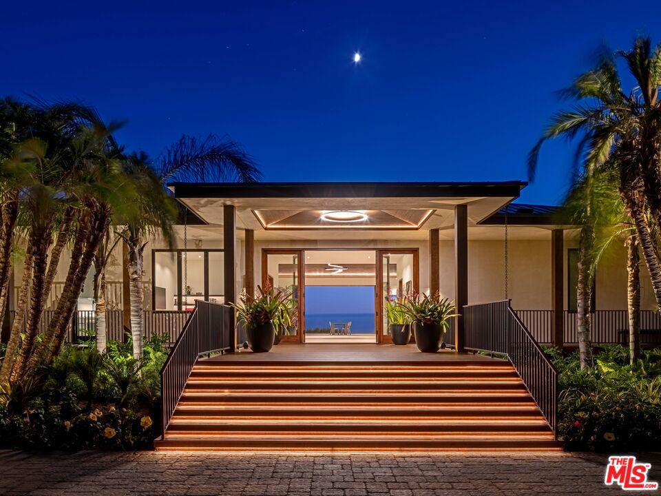 Wake up to the tranquil sounds of waves, running streams, wild parrots and the wind rustling through the property's nearly 300 trees. Uniquely designed by Doug Burdge, A.I.A. as a tropical single-story compound, the main house is separated from the guest house by a running stream and connected via a glass bridge. Spread out throughout the compound are two garages, a tennis bathroom, and a pool pavilion. The estate, one of just 17 properties located in the exclusive 80-acre MariSol Malibu community, is a net zero carbon home that is 100% electric, featuring Tesla batteries, solar panels and EV charging. The great room is ideal for entertaining large groups and exemplifies indoor/outdoor living with its 20-foot tall wooden ceilings. The main kitchen is appointed with Miele and Gaggenau appliances, three stone countertops with seating for eight, and is also connected to a fully stocked butler's kitchen. On the other end of the great room is a large stone bar with seating for six, a beer tap and two refrigerated Gaggenau wine closets. The exterior grounds include edible passionfruit, hibiscus and a professionally maintained organic fruit orchard and vegetable/herb garden pollinated by on-site beehives (complimentary beekeeper and farmer included for 1 year). The nearly 2,000 sqft primary suite has views and sounds of whitewater and the infinity edge pool to lull you to sleep. The suite includes a shou sugi ban water vapor fireplace, warm wooden ceiling, motorized doors and drapes, a giant Poliform walk-in closet, a dual porcelain shower, and a rain-shower bathtub overlooking the ocean. This estate is a paradise for wellness seekers and includes organic fruits and vegetables, a fully-stocked gym, steam room, Redwood sauna, water filtration system and a hospital-grade Merv 13 ventilation system. Outdoor amenities include a heated infinity-edge pool, a spacious lawn, basketball court, full size tennis court, and putting green. The estate is move-in perfect with comfortable modern furniture, curated paintings from local Los Angeles artists, and one year of professional estate management. Walk with your surfboard to the famous surf break, County Line Beach, made famous by The Beach Boys, and grab lunch afterwards at the famous Neptune's Net Restaurant, or quickly access some of the best hiking trails in the Santa Monica Mountains. Don't miss out on this luxurious, wellness inspired, net zero retreat and schedule your private showing today!