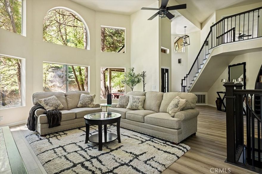 Fully Furnished Lake Arrowhead Retreat – Ideal for Traveling Professionals in Transition or waiting for a construction project to get finished. Available NOW for Monthly Stays (or longer) 4BR | 4BA | 3,196 Sq Ft | Sleeps Up to 10. Enjoy all four seasons in this beautifully remodeled and fully furnished custom mountain home. Perfect for those in need of temporary housing from one month to one year. Nestled among majestic dogwood, cedar, and oak trees, this spectacular home features 4 spacious bedrooms, 4 bathrooms, multiple living spaces including a family room, game room/office, and a bonus entertainment level with separate entry - a potential guest suite. The main level living room welcomes you with a wall of windows, flooding the space with natural light and framing forest views. Relax by the wood-burning fireplace as you watch snowfall in the winter or enjoy the golden colors of fall. The chef’s kitchen is fully equipped with an island boasting a NEW LG Signature double oven dual-fuel range, and stainless steel chef’s sink with filtered water. Each level of the home includes a cozy fireplace, new luxury vinyl plank flooring, and plush Shaw carpeting for added comfort and durability. The master suite is a true retreat, complete with a sitting area, private deck, dual-sided fireplace, oversized NEW 6-ft Jacuzzi tub, walk-in double shower, and quartz-topped vanities. A vintage clawfoot tub highlights the main-level bath, adjacent to a bedroom with walk-in closet. Step outside to a furnished patio with a propane fire pit—perfect for dining or lounging under the stars. The attached 2-car garage, level entry, and RV-friendly parking add convenience, while county-maintained/plowed roads ensure easy access year-round. Located just 5 minutes from Lake Arrowhead Village, the lake, SkyPark, grocery stores, restaurants, hospital, and pharmacy. Only 24 minutes to Snow Valley Ski Resort and a scenic commute to Loma Linda, Redlands, or San Bernardino. Additional Highlights: High-speed fast wifi included. On-site laundry. Pets allowed (with approval - extra cost is negotiable). Utilities included. Lots of free parking. Monthly Rent: $5,175. Minimum 1-month stay.
