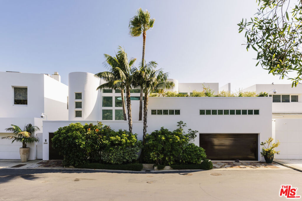 A visionary architectural statement along the sands of Malibu Cove Colony, this sculptural beachfront residence exemplifies the harmony between form, light, and the Pacific horizon. Conceived as both a work of art and a livable sanctuary, the home is enveloped in walls of glass and sweeping organic curves, where each line is drawn toward the sea. With 60 feet of ocean frontage, multiple terraces, and panoramic vistas stretching from Point Dume to Palos Verdes, every room becomes a front row seat to nature's performance. Inside, soaring ceilings and skylights pour daylight across fluid, gallery like interiors that blend contemporary sophistication with a serene coastal palette. The main living area unfolds seamlessly with living, dining, and kitchen spaces unified by transparency and light. A sleek fireplace anchors the space, while the kitchen's stainless steel appliances, bar seating, and built in banquette evoke both utility and style. Step through glass doors to the full width oceanfront balcony, a stage for golden sunsets and intimate al fresco dinners. Above, a tranquil loft office and sitting area opens to an expansive deck, with exterior stairs ascending to a private rooftop retreat, perfect for sunbathing or quiet reflection. Below, three serene bedrooms, each with ensuite baths, offer restful privacy. The primary suite, a masterful composition of texture and tone, features a sitting area with fireplace, a spa inspired marble and limestone bath with a soaking tub poised before the sea, and a private terrace that frames the coastline in cinematic splendor. Set at the end of a prestigious guard gated enclave, this Malibu Cove Colony residence is more than a home; it is a modern sculpture in glass and light, celebrating the seamless dialogue between architecture and ocean.