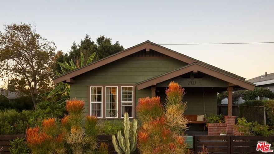 Set behind vibrant landscaping and a welcoming front porch, this 1914 Craftsman radiates warmth, restoration, and enduring charm in the heart of Jefferson Park HPOZ. A delight for preservationists and design lovers alike, the home balances modern updates with storied character, revealing spirited salvaged treasures throughout. Inside, a vaulted open-concept living room centers on a beautifully restored fireplace clad in zellige-style tile and framed in rich tigerwood. The light-filled living and dining areas flow effortlessly into a cheerful, modernized kitchen lined with terrazzo floors, Fireclay tile, and quartz countertops. Outfitted with luxury Cafe appliances, the space is both functional and exuberant place for gathering, cooking, and creative living. Between two serene bedrooms with custom expanded closets lies a spacious, luxuriously Zia tiled bathroom. Beyond, the rear bedroom opens to a private patio made for al-fresco dining complete with a hot tub and a side yard framed by mature cacti and a fruiting banana tree. Along the perimeter, a free little library and neighborhood plant stand celebrate the home's spirit of community and sharing. Recent structural and system upgrades include new electrical and plumbing, a fortified foundation, and air conditioning. A spacious attic and new 16-foot shed offer ample storage. More than just an architectural style, this home reflects an architectural philosophy that sees living space as both sanctuary and social fabric. Ideally situated near neighborhood favorites like Highly Likely, Maydan Market, Vicky's All Day, Cafe 5, Peace Awareness Labyrinth & Gardens, and the historic William Andrews Clark Memorial Library. Enjoy ultimate centrality with quick access to Culver City, Mid-Wilshire, Hollywood, and the Westside.