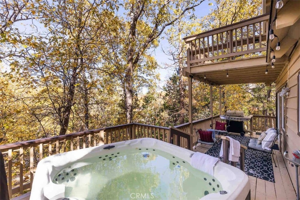 This warm and welcoming two-story cabin is all about comfort, connection, and the kind of mountain moments you don't get in the city. Downstairs, you'll walk into a cozy living area with a TV, comfy seating, and space to relax together the couch folds out into a bed for extra sleeping space. The fully equipped kitchen has everything you need to cook full meals, plus a laundry area just off to the side for convenience. Sit down for meals at the dining table. There's also a downstairs bedroom with a double bed and a desk setup, perfect for anyone needing a little quiet time to read, write, or catch up on emails. The downstairs bathroom has a tub/shower combo.
Upstairs, the master bedroom features a California king bed, TV, and a private balcony with a table and chairs, just right for sipping coffee among the trees. Another bedroom upstairs has two double beds and its own TV, giving plenty of options for different groups or families. There's also a second full bathroom upstairs with a walk-in shower.
Outside, there's room for two vehicles in the driveway and a hot tub waiting for you after long hikes or days on the slopes. You'll have passes that give you access to the lake, which is just three-minutes from the property, great for picnics, walks, or a swim. Whether you're unwinding in the jacuzzi or hanging out in the living room with a board game, the vibe here is laid-back and easy. The cabin is surrounded by trees, so you'll feel tucked away without being too far from town or the lake. Security is covered with Ring and ADT cameras on-site for peace of mind.
Neighborhood overview
Lake Arrowhead has that classic mountain-town charm, tall pines, winding roads, and fresh air that hits different up here. Whether you're here for hiking trails, snow days, or just time to breathe and recharge, the town has an easy pace that makes it feel like a true getaway. Locals stop by the village for a coffee, a lakeside stroll, or weekend markets. It's a community that loves nature, quiet evenings, and good company.