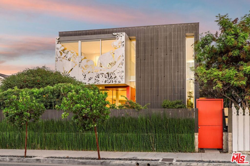 Welcome to The Poppy House, an iconic Venice architectural retreat. A rare opportunity to own one of the area's most distinctive residences, The Poppy House is a striking fusion of design, light, and coastal living. Envisioned and built by architects Jonathan Ward and Jin Ah Park as their personal home, it takes its name from the poppy-shaped cutouts adorning the metal facade. Featured in Dwell and Mansion Global, this celebrated property blends sculptural elegance, mid-century warmth, and sustainable innovation. Just five blocks from the beach and minutes from Abbot Kinney, it offers the quintessential Venice lifestyle. Inside, walls of glass and soaring ceilings flood the interiors with natural light, showcasing an open floor plan that seamlessly connects formal living and dining areas, a cozy lounge, and a sleek chef's kitchen with Miele appliances and warm wood cabinetry. A full bath with a Japanese soaking tub on the main level provides a serene space to relax and recharge. Sliding glass doors open to a lush central courtyard, the centerpiece of the home, perfect for gatherings around the fire pit or dining under the stars. Beyond, the landscaped backyard offers a built-in BBQ and a spacious spa for eight, creating an inviting space to entertain and unwind. Sustainable by design, the home is equipped with rooftop solar, radiant underfloor heating, and passive cooling, creating a true net-zero residence that delivers year-round comfort without compromising luxury. An oversized three-car garage can be used as a flexible studio/office and comes with fully designed, permitted plans for a stunning ADU with two bedrooms and an open-concept living area above, ideal for guests, creative pursuits, or income potential. A rare blend of artistry and ease, The Poppy House captures the heart of Venice living.