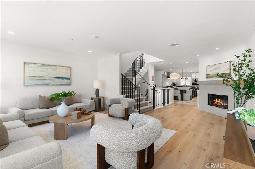 Experience iconic Corona Del Mar living in this completely reimagined 3-bedroom, 2.5-bath ocean-view home, offering unparalleled comfort and style—as well as parking for up to 9 cars! Situated on a quiet cul-de-sac just one block from the ocean on the coveted 300 block of Carnation Ave. and featuring stunning panoramic views of Newport Harbor, Fashion Island, and the Pacific Ocean, this idyllic home redefines the modern seaside lifestyle. Step inside to discover a light-filled, open-concept layout enhanced by designer finishes throughout including wide-plank wood flooring, modern lighting, custom paint, and ultra-quiet ceiling fans. The spacious living room features a wall of custom windows that invite natural light and fresh ocean breezes, complemented by a new contemporary fireplace with wood mantle. The gourmet chef’s kitchen is a showstopper, equipped with stone countertops, modern cabinetry accented by stylish herringbone backsplash, an oversized island with waterfall edges, and top-of-the-line stainless steel appliances: 6-burner range with double oven, hood, microwave, warming drawer, oversized refrigerator, and wine fridge, ideal for culinary enthusiasts. A chic wet bar with a second wine fridge and a cozy office nook completes the space, perfect for both entertaining and everyday living. Upstairs, the resort-inspired primary suite features a cozy fireplace, wall-mounted flat-screen TV, Walk-In Closet, and built-in designer wardrobes with elegant lighting. The spa-like en-suite bath includes dual vanities, a soaking tub, a walk-in shower with skylight, and custom tilework for a truly luxurious experience. The expansive patio offers plenty of space for entertaining and enjoying breathtaking views of the harbor & ocean as well as gorgeous sunsets. The lower level offers 2 additional bedrooms, each combining high design with modern comfort. For the car collector or hobbyist, the finished 3-car garage features epoxy flooring and storage, and room for 3-5 additional vehicles on the driveway, depending on size. This offers versatile options for a home office, gym, or car collection, all with hassle-free parking. The exterior has recent updates including new roofing, paint, rain gutters, sprinklers, landscaping, and lighting. Located steps from the beach and CDM Village’s cafés, boutiques, fine restaurants, and just minutes from legendary surf, freeway access, Fashion Island, and top-rated schools, this immaculate home offers coastal living at its finest.