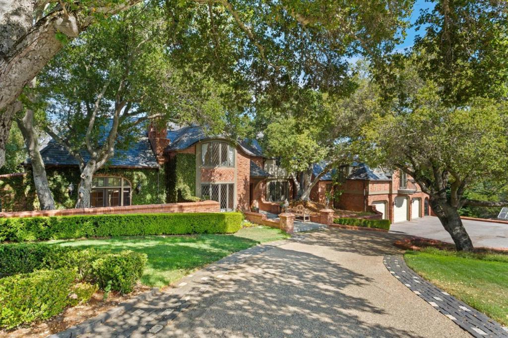 LUXURIOUS ARCHITECTURAL MASTERPIECE | Immerse yourself in an enchanting world of timeless sophistication, up-to-the-minute luxury, and absolute privacy. This gated hilltop estate is equally elegant and inviting, showcasing meticulous craftsmanship and breathtaking views of the foothills & Bay. Extensive remodeling balances classic details with bright, versatile rooms fitted for modern enjoyment. Luxurious elements include layered millwork, leaded-glass windows, oak herringbone floors, and Calacatta marble. Gathering spaces open to scenic terraces - perfect for grand-scale entertaining and casual everyday living. Opulent primary suites reside on both levels. Majestic heritage oaks frame the level grounds, and the dazzling pool retreat boasts a spa, sauna, pool bath, and outdoor kitchen. Highlights include a mahogany library, couture closet, gym, stately fireplaces, wine cellar, tech wiring throughout. Near prized Los Altos schools and some of the world's most prestigious tech campuses