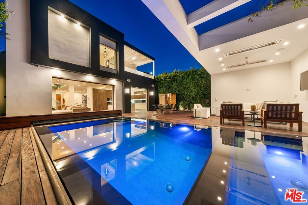 2015 Ultra High-End Construction, Private and Gated 5 bed/5.5 bath, 4,088 sq ft modern showcase home with resort style pool/spa/cabana, a 5th bedroom that has been converted into a movie theatre, and over 900 sq feet of roof deck & balcony space with spectacular 360 Degree Views all located in Iconic and tree-lined Sunset Square. Seamless indoor/outdoor living with pocket doors opening to the West-facing backyard featuring an awe inspiring outdoor oasis with a zero-edge saltwater pool and spa, complemented by a stylish cabana with its own indoor shower and bathroom. The gourmet chef's kitchen boasts custom Italian cabinets, Miele appliances, Caesarstone counters, breakfast bar, and a built-in espresso station. An architecturally stunning floating and pendant lit staircase serves as the centerpiece of the downstairs, while hardwood floors throughout connect meticulously appointed living spaces featuring multiple fireplaces and expansive windows that flood the home with natural light. All bedrooms have en-suite bathrooms with 1 guest bedroom/office downstairs and 4 upstairs. The 5th bedroom upstairs which was converted to a screening room comes complete with screen and Dolby 7.1 audio surround sound, perfect for entertainment. The primary suite features a fireplace, large his and her walk-in closets, spa style primary bath, and west facing terrace perfect for watching the sunset. A convenient 2nd floor laundry room adds the perfect functionality, while a sprawling roof deck w/ firepit features striking views of the Hollywood Hills and downtown. Premium technology includes Control 4 smart home automation, electric pool/spa cover as well as central pool/spa temp and lighting control, electric shades, central controlled indoor and outdoor speakers, full alarm system plus security cameras, dual Heating and Air Systems, and much more! Located just minutes to the Sunset Strip and Runyon Canyon, this exceptional residence representing the pinnacle of modern luxury living truly checks all the boxes. A must see masterpiece!
