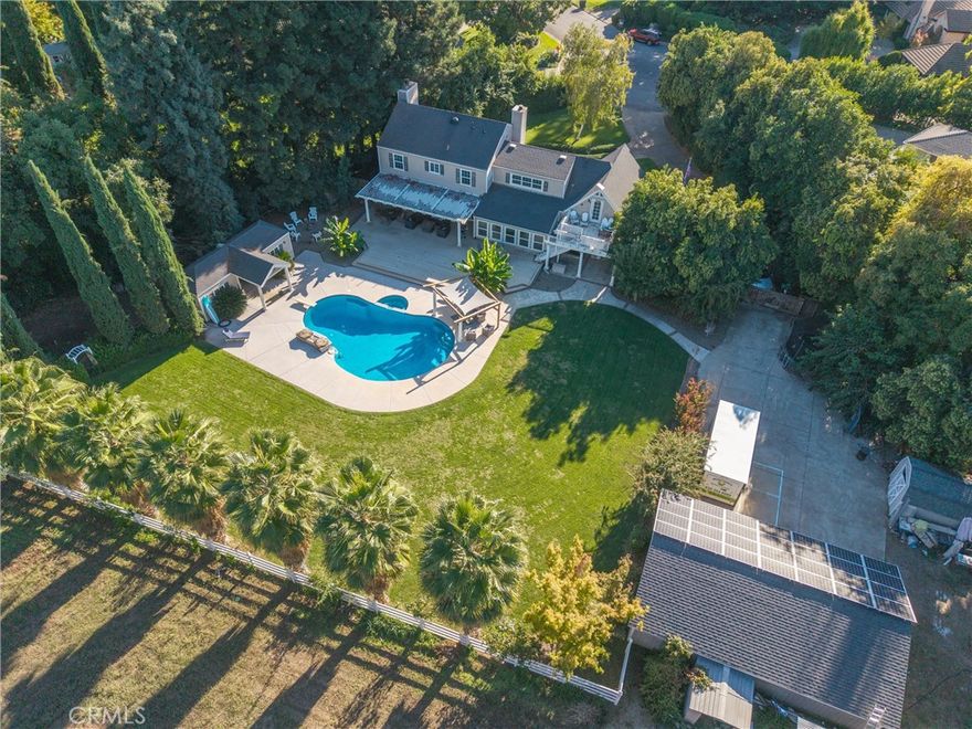 This Cape Cod–style estate blends timeless character with thoughtful updates. Spanning over 3,100 sq. ft., with 4-bedrooms plus Art Studio or 5th bedroom with separate entrance and 2.5-baths. This home has been re-imagined through the years to create an open and versatile floor plan. The original walls into the living and formal dining rooms were opened up and accented with graceful pillars, giving the main level a spacious, flowing design perfect for gatherings. A large family room was added for casual comfort, and upstairs you’ll find a private art studio with a balcony overlooking the lush grounds. The chef’s kitchen serves as the heart of the home with a large island for seating, double ovens, granite countertops, and abundant storage. Throughout the home, hardwood and tile flooring, recessed lighting, and elegant wainscoting add to the warm, inviting feel. The primary suite offers a cozy fireplace and generous space for a sitting area, while the bath includes granite counters for a polished touch. Outdoors, the property truly shines. The beautifully landscaped backyard features a sparkling in-ground pool, tranquil water feature, poolside gazebo, and a covered patio that seamlessly extends indoor living outdoors. A pool pump house with a changing room and storage, plus an updated pool pump, ensures easy entertaining.

Set on 1.2 acres, the property offers room to roam. Once home to horses, the back area is now a garden and play space, while the former barn and stalls have been converted into a 24x34 shop, perfect for projects, hobbies, or extra storage. Additional highlights include owned solar for efficiency and the rare opportunity to live in one of Chico’s most iconic neighborhoods where tradition, community, and holiday spirit make every season unforgettable.
