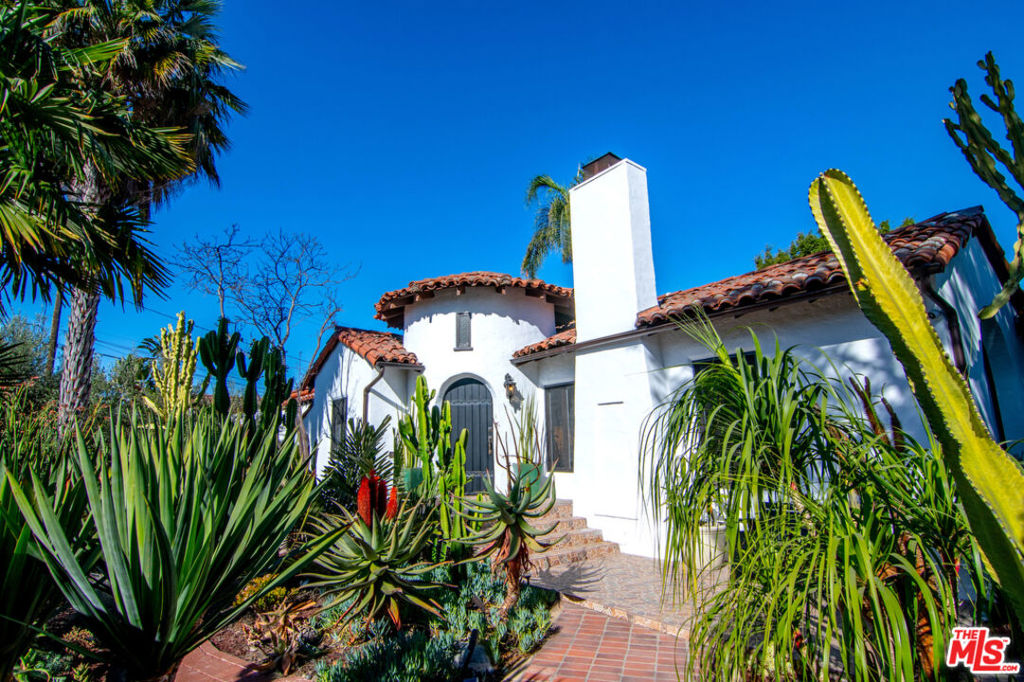 STUNNING AND ULTRA-PRIVATE SPANISH SANCTUARY IN BEVERLY GROVE. Ideally located in this highly sought after neighborhood, enter this 1920's Spanish home through a beautifully designed drought-tolerant garden and front patio into an expansive living room with a vaulted, wood-beamed ceiling, picture window and fireplace. Three bedrooms include an ensuite primary bedroom with a luxurious marble bath and a second bathroom with gorgeous custom tile work. A remodeled, open-concept island kitchen and dining room features Caesar stone and granite counters, farm sink, Subzero and Wolf stainless steel appliances, a wine fridge, pantry with custom sliding shelves and side entry leading to a fabulous entertainer's backyard with a covered dining patio, bubbling fountain, full outdoor kitchen and bar, and a relaxing lounging area with firepit. The garage has been nicely finished for use as a bonus flexible space/office/entertainment room with a murphy bed and a ductless HVAC system. Additional features include central AC, wide plank Italian oak floors, indoor/outdoor sound system, separate laundry room with additional storage, custom window treatments, and Nest thermostat. Fully gated and centrally located just a stone's throw from L.A.'s best shopping and dining, on Third Street, The Grove, West Hollywood and Beverly Hills, this amazing home has it all.
