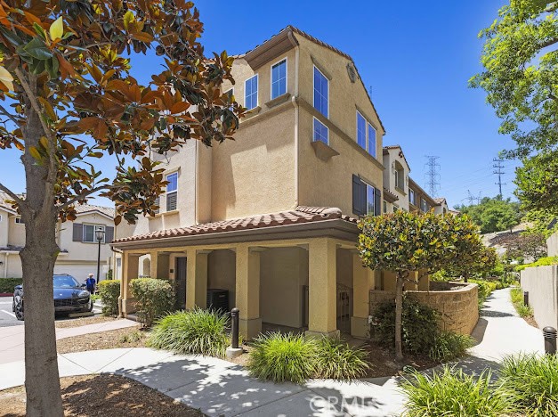 Location, Location, Location. Welcome to this prestigious Hillside Retreat (Sunset Ridge) a prime location in a picturesque gated neighborhood This beautiful tri-level corner lot residence offers the feel and privacy of a single-family home. Thoughtfully designed this spacious property combines comfort, convenience, and stunning hillside views. Entry Level: Enjoy direct access from the attached 2-car garage into a private en-suite bedroom with its own patio – ideal for a guest suite, home office, or bonus room. Second Level: The heart of the home features a soaring-ceiling great room, bathed in natural light, and a generous kitchen with dark granite countertops, breakfast bar, and abundant storage. Also on this level are a full bathroom, laundry closet with side-by-side hookups, and a sizable second bedroom. Third Level: Upstairs you'll find a spacious primary suite complete with its own bathroom, big walk in closet, and an adjacent loft area – perfect as a reading nook, work space, or lounge. All appliances, including the washer and dryer, are included Complex amenities include Enjoy all the perks of luxury living with a low $475 HOA, complex amenities include access to a resort-style pool, hot tub, cabana, beautiful BBQ area, walking path with views, and much more! Close to shops, blue ribbon schools, restaurants, 405 and 5 freeways. Central to all.