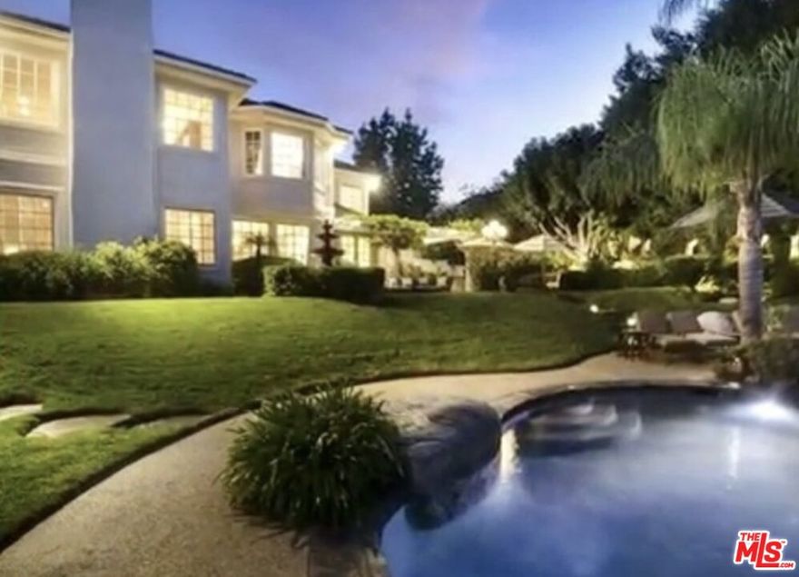 Exquisite residence nestled in the highly coveted, exclusive guard-gated community of Mountain Park Estates. Tranquil, Zen-inspired gardens frame the covered trellis that leads to a stunning grand foyer. Elegant entertaining spaces feature gleaming hardwood floors, vaulted ceilings, and a spacious family room, perfect for both gatherings and everyday living.The chef's kitchen is designed for both style and function, boasting a center island, six-burner range, wine refrigerator, walk-in pantry, and a bright, sun-drenched breakfast area. The master suite opens through French doors to a private balcony, offering serene views of the entertainer's backyard and sweeping valley vistas.The backyard is nothing short of spectacular. Whether enjoying the sun by day or the serenity of twilight, it embodies true resort-style living. Lush landscaping surrounds a saltwater lagoon-style pool, gazebo, and multiple patios, while expertly placed lighting casts a mesmerizing glow that enhances the ambiance.All this, just minutes from Malibu's sandy beaches and the chic shops and restaurants at The Commons, combining luxury, comfort, and the ultimate Southern California lifestyle.
