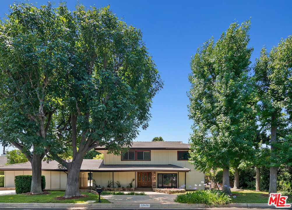 Located on a quiet cul-de-sac in the sought-after Devonshire Highlands neighborhood, this spacious home is situated on a beautiful 16,725 sq. ft. lot and is being offered for the first time in 25 years. A formal entry leads to generous living spaces, including a step-down living room with a mantled fireplace, a large family room with built-in bookcases, a formal dining room, and a kitchen with a cozy breakfast area. Hardwood and stone flooring run throughout the home. French doors from the family room open to a large, covered patio and an expansive backyard featuring a swimmer's pool, sports court, firepit, grassy play areas, and mature gardens. Upstairs, there are four bedrooms, including a primary suite with its own fireplace, a dressing area with vanity, and three closets one of which is a walk-in. Downstairs, an additional bedroom with an adjacent bathroom is ideal for guests or a home office. A spacious laundry and utility room offers extra storage, a sink, and a secondary entry to the home. The property also includes a three-car garage plus extra driveway spaces for additional vehicles or an RV. Fully paid off solar panels!
