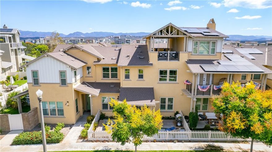 This beautifully upgraded home blends modern design with luxury finishes throughout. From the moment you arrive, you'll be captivated by the spacious front yard, and oversized covered patio—complete with built-in seating and a cozy firepit, perfect for entertaining or enjoying a quiet evening outdoors. Step inside to discover an open-concept layout featuring elegant vinyl plank flooring, fresh interior paint, plush new carpet, recessed lighting, and upgraded baseboards. The bright and airy living room flows effortlessly into a dining area and a chef-inspired kitchen equipped with stainless steel Energy Star appliances, a gas range with hood and griddle, a self-cleaning convection oven, modern tile backsplash, gorgeous quartz countertops, and a large center island with farmhouse sink and breakfast bar. Upstairs, the luxurious primary suite offers a true retreat with a spacious walk-in closet, beautifully upgraded ensuite bathroom with tiled shower and floor, quartz countertops and dual vanities. Two additional bedrooms, a full guest bathroom with dual sinks, and an upper-level laundry room with added cabinetry provide plenty of space and convenience for daily living. The third-level covered rooftop deck boasts panoramic mountain views and is ideal for BBQs, al fresco dining—with a built-in sink, refrigerator, and counter space—or simply lounging with a built-in TV setup. Additional home features include touchless keypad entry, custom window coverings including wood shutters and blinds, double pane windows, upgraded light fixtures, downstairs framed mirror, modern hardware, direct access 2-car garage with overhead storage and ball rack, and Energy Star features integrated throughout the home. You will also have access to award-winning amenities such as baseball fields, playgrounds, a sports park, the Canyon House, Blue Hummingbird Coffeehouse, The Pond, Lagoon and Lake, Camp Out facility, resort-style pools, the farms, an arcade, state-of-the-art workout gyms, dog park, a zipline, splash pads, biking trails, NEV roads, and tennis and pickleball courts (to name a few). Additionally, it is just 15 minutes from the beach and conveniently located near the 241 freeway