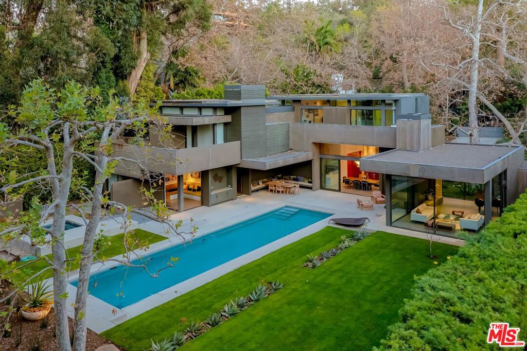 This Architectural Masterpiece by Chu + Gooding Architects in SM Canyon is an exceptionally well designed home on an expansive private, serene lot. Perfectly positioned to capture light throughout the day w/ views of mature sycamores & redwoods the seamless design allows nature to be the Art. Opening to this natural park setting the home includes: glass walled living room w/wood burning fireplace, chef's kitchen w/butler's pantry, dining room for entertaining w/fleetwood sliding glass walls to large outdoor patios, cozy media room, 6 large bed, 5 baths, 2 powder rooms, extra reading nooks, & 2 private offices. The large grassy backyard with a swimmer's pool &private spa, outdoor dining room, wood burning fireplace, raised veggie gardens, mature fruit trees all abut a natural spring feed creek. Lush hillside & wild garden offering an abundant wildlife setting, this exquisite piece of contemporary architecture is located on one of the most private, serene roads in SM Canyon.