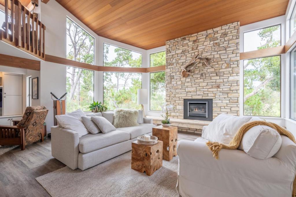 Tucked in Monterey's coveted Deer Flats Park sunbelt, this inviting home offers a rare blend of elegance, tranquility, and connection to nature. Morning light filters through soaring windows in the dramatic living room, where rich wood accents and a striking fireplace frame forest views. The serene primary suite, with its cozy window seat, fireplace, dual closets, and private spa patio, is a perfect place to unwind and relax. Two additional bedrooms and a full bath provide privacy and comfort for family or guests, while the gourmet kitchen flows easily to the adjacent den and office nook. A versatile artist loft with sink offers an inspiring space to create and dream. Thoughtful decks invite gatherings under the trees, and a spacious two-car garage adds convenience to this peaceful, nature-inspired retreat.
