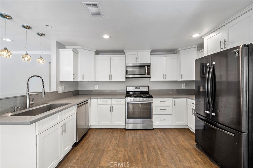 MOVE IN READY!!! This beautiful 3 bedroom, 2 bath home in the heart of Santa Ana is just waiting for you to call it "home". Enter the front to find a spacious living room, open to the gorgeous and upgraded kitchen, which features quartz counter tops, white cabinets, recessed lighting, stainless steel appliances, and custom pendent lights. And the kitchen isn't just upgraded, it's perfectly designed for hanging out with family and friends while preparing a meal or serving company in the dining area. This spacious layout continues throughout the entire house and has upgraded flooring in nearly every room. And between the open floor plan and all the natural light, you'll never find yourself feeling crowded or claustrophobic. All bedrooms and bathrooms are located on the main living level, so if you have family or friends that don't do well with stairs, don't worry! The layout of this home will be perfect for you. But that's not all... both bathrooms are upgraded as well, featuring custom tile work, newer sinks, quartz counter tops, and upgraded lighting! Oh, and wait until you see the backyard. Talk about open, this massive yard is ideal for entertaining, throwing backyard barbecues with family and friends, or hosting private family events. In the front is a security gate, and once open, you can easily park your cars on the driveway. A garage is located on the property, but be sure to inquire to find out more. This home is in great, move-in condition, all its needs now... is you!