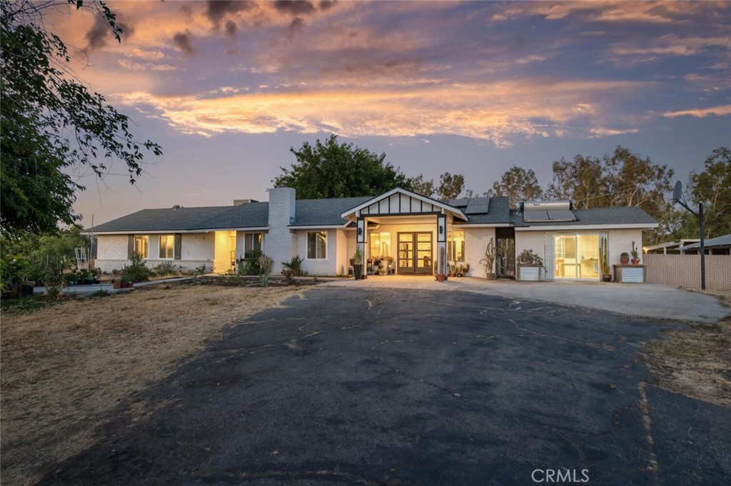 This beautiful 4bd, 2ba ranch-style home offers 2,189sf on 2.27 acres in Golden Valley Unified. Property highlights include owned solar, a new well and pump (2024), 40x60 shop, barn with 2 stalls + hay storage, studio (currently used for tack), pool with rock accents, new iron fencing, and a security gate. A welcoming front porch with upgraded architectural details sets the tone for the updated interior. Inside, the open-concept layout features vaulted ceilings and modern finishes. The great room connects seamlessly to both the front and backyard through French doors. The kitchen includes white cabinetry, stainless appliances, and a large center island with counter seating. There's also a dining area and a second living room with a painted brick fireplace. The primary suite includes an attached bath with a beautifully updated step-in shower, complete with dual shower heads and a built-in bench. A lighted arena and a dedicated dog run complete this versatile country property. Out back, the fenced pool area includes grid-style pavers, mature shade trees, and natural rock accents.