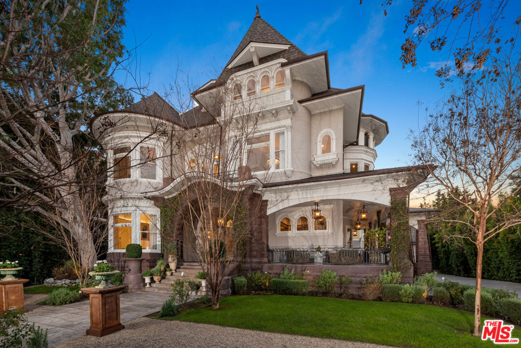 Situated in the heart of Hancock Park, this stunning Victorian home infuses the beauty of modern elements with historical charm. Designed by the renowned John C. Austin, best known for The Griffith Observatory, this home stands as one of the last early Wilshire Boulevard homes still in existence. Recently reimagined by architect and designer Xorin Balbes, this 9-bedroom, 11-bathroom home effortlessly emulates luxury while spanning four floors and encompassing over 13,000 square feet. The main level welcomes you through a grand foyer and showcases a living room that opens to an elegant formal dining room, music room and media room. The gourmet chef's kitchen provides a large center island, top-of-the-line appliances including a wine fridge, butler pantry, and sunny breakfast room. Upstairs sits the primary bedroom with a spa-like bathroom that has dual vanities, a free-standing tub near a fireplace, and large walk-in closet. Additional features include a yoga room, custom gym, billiards room, den/office, soaring ceilings and abundant windows that provides abundant natural light throughout. An entertainer's dream, the backyard has matured landscaping that offers ample privacy, a grand pool and spa, BBQ, fire-pit and a detached guest house with full kitchen and two additional bedrooms. Rich in history, this cultural masterpiece truly has it all.
