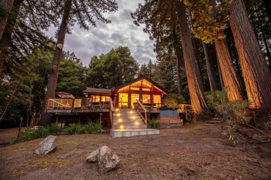 Welcome to 4600 Trout Gulch Rd where you'll find 12 magical acres near the western edge of Nisene Marks State Park. The house and barn are thoughtfully placed amongst towering redwoods that demonstrate the true scale of this amazing area. Enjoy stunning greenbelt views from the living room, kitchen, and viewing decks with a brand new hot tub. The warm and cozy cabin style interior provide the perfect escape from reality and is complete with a chefs kitchen. The property is networked by Starlink internet for those looking to stay connected in the peaceful redwood setting. The property provides plenty of usable flat land which features multiple custom built sheds and a 1600ft barn/workshop with a loft that is permitted as office space. Fed by your own private well, you receive plenty of sun for growing which is evident by the wine vineyard next to the driveway that produces enough grapes to make your own wine. The barn is already equipped with everything needed to start producing wine on the next harvest. Just 10 mins from Aptos Village, you're going to want to see this propery's first time on the market in 30 years.