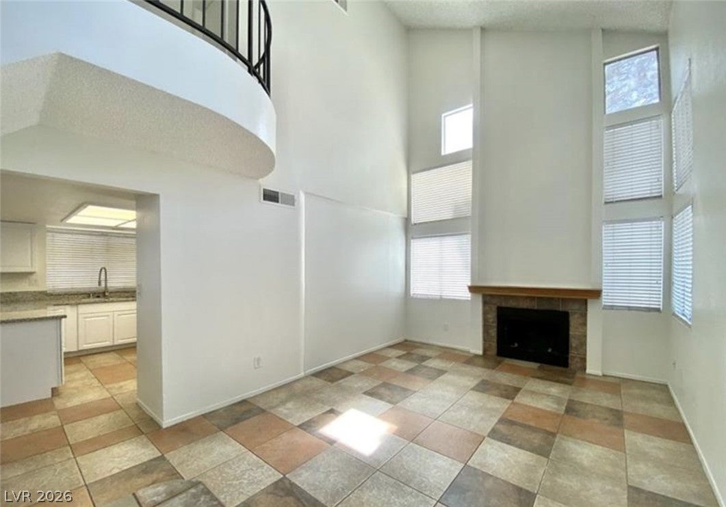  living room with a tiled fireplace, lofted ceilin