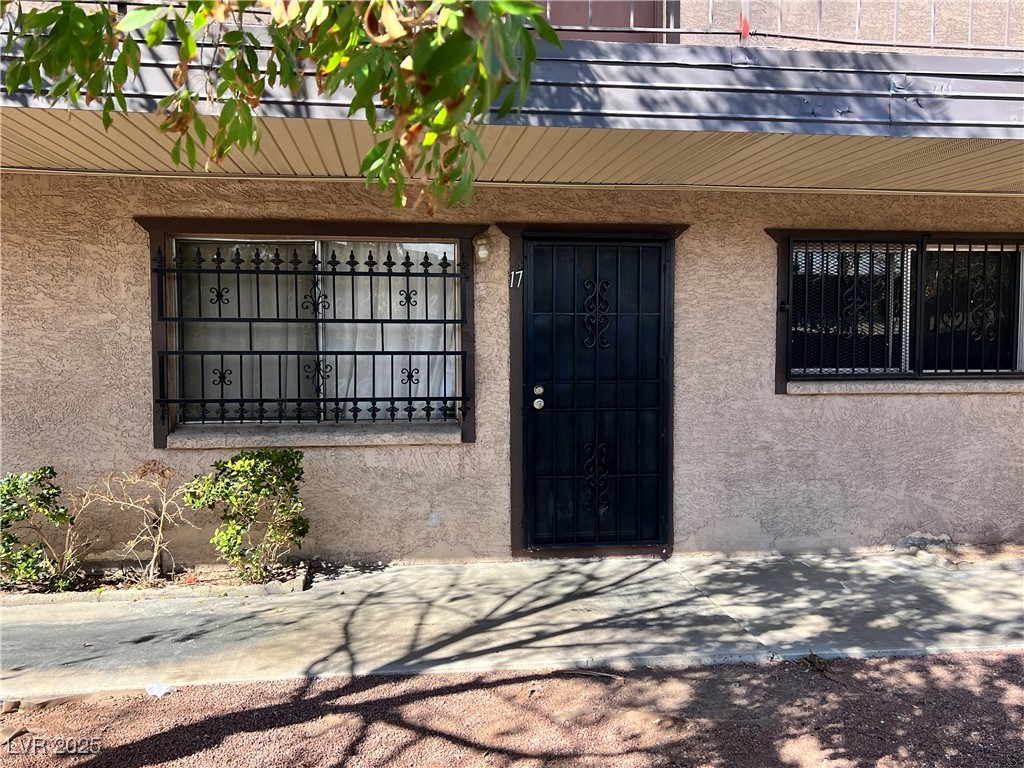 Doorway to property featuring stucco siding