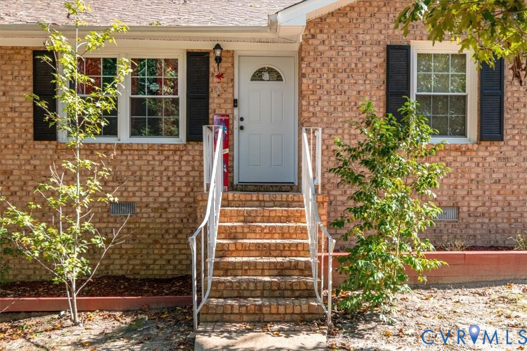 Entrance to property with brick siding and crawl s