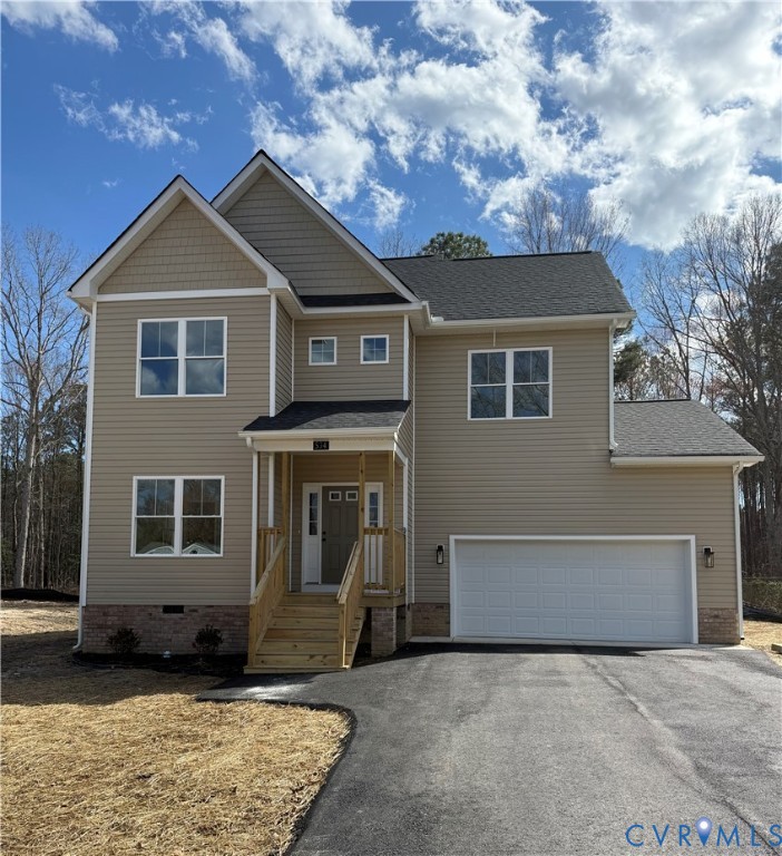 View of front of property with asphalt driveway, a