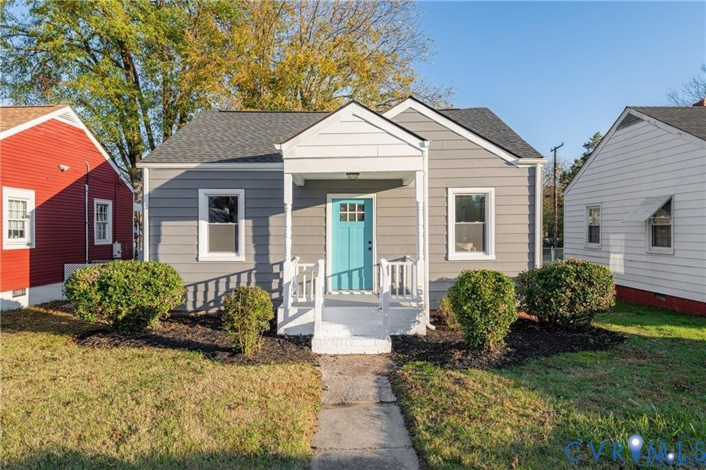 Bungalow with a front yard and a shingled roof
