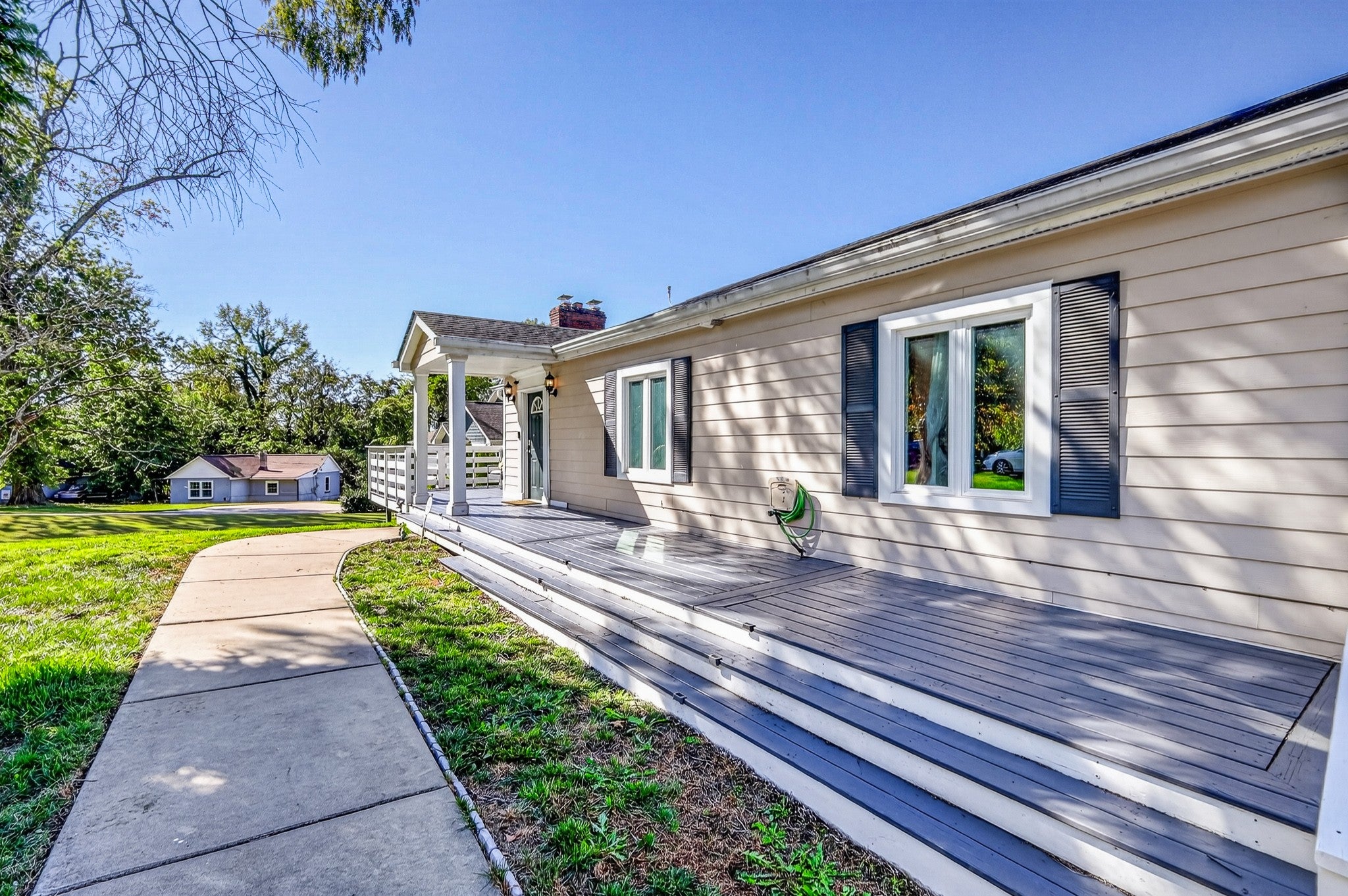6-bed home for sale in Old Hickory, TN 37138, 130 Park Cir Gray composite deck running along the side of a tan home with a covered entry and a concrete walkway