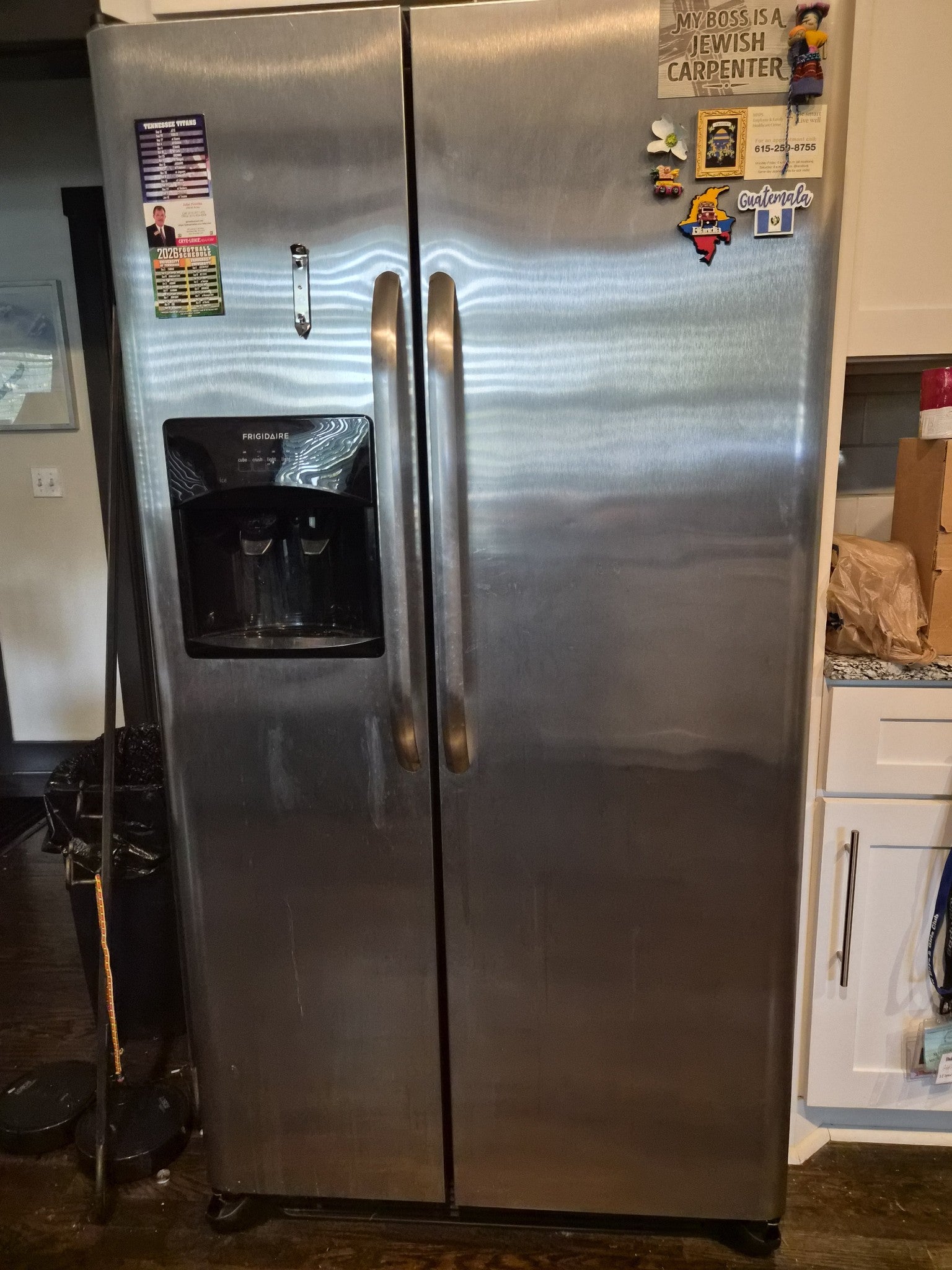 Stainless steel side-by-side refrigerator with an ice and water dispenser in the kitchen