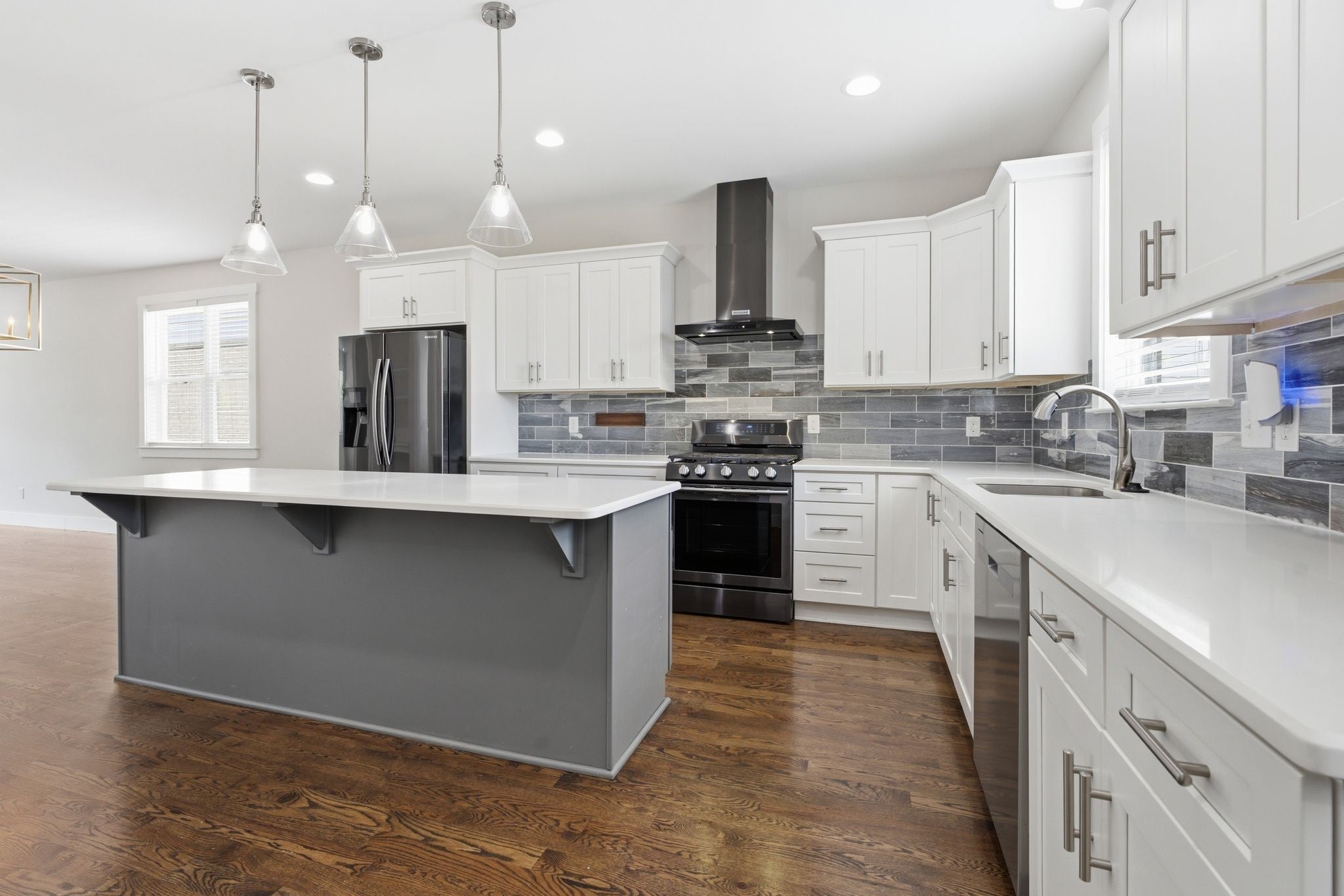 3-bed condo for sale in Old Hickory, TN 37138, 2205 Dabbs Ave Kitchen with white cabinets, gray tile backsplash, stainless steel range and refrigerator, and wood floors