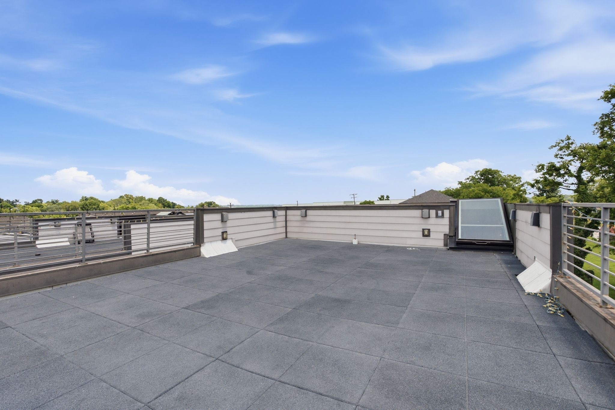 3-bed condo for sale in Old Hickory, TN 37138, 2205 Dabbs Ave Rooftop terrace with dark tile pavers, metal railings and a view over the trees and rooftops