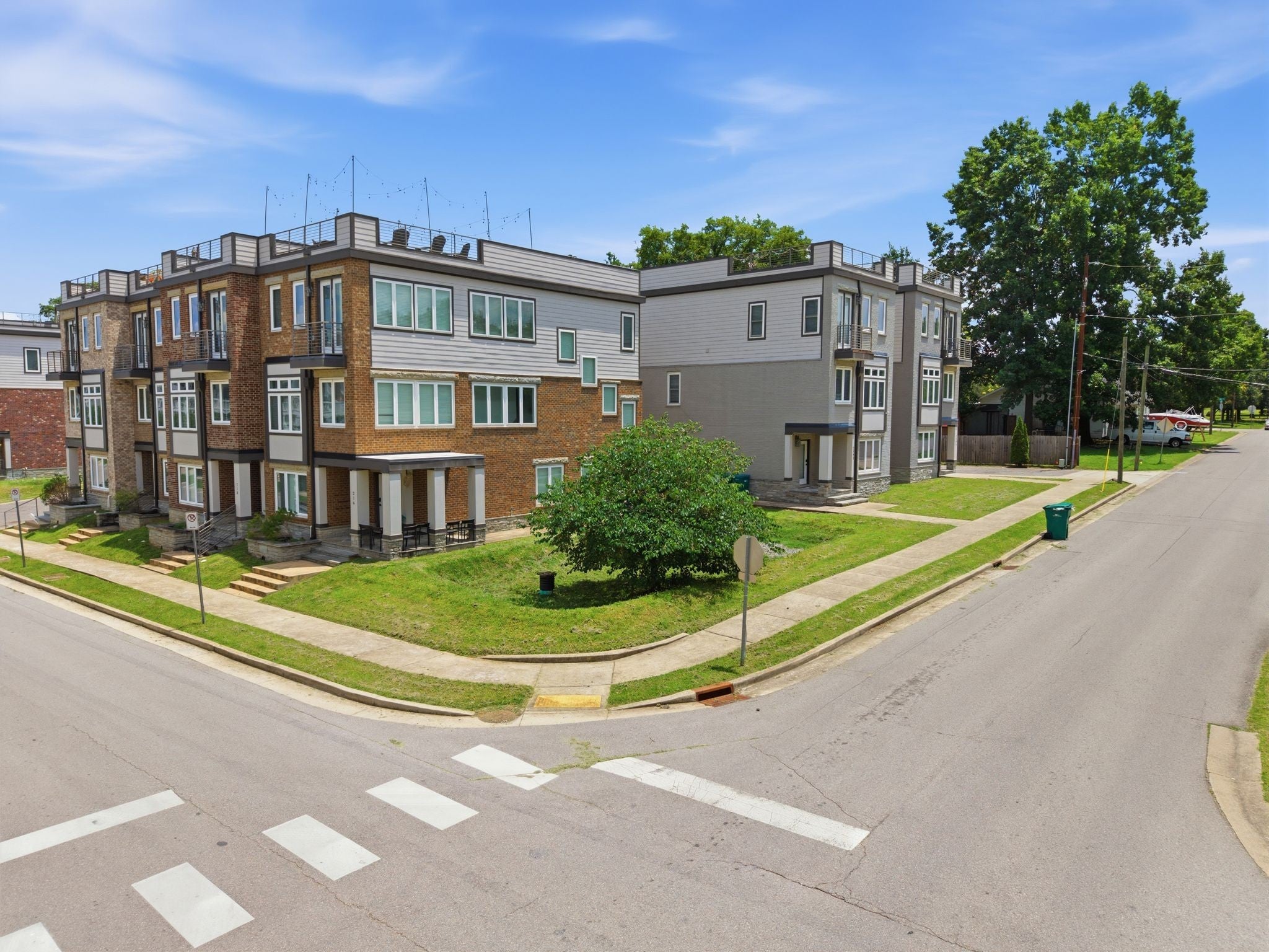 3-bed condo for sale in Old Hickory, TN 37138, 2205 Dabbs Ave Exterior view of a row of three-story townhomes with brick and siding facades, lawn and sidewalks
